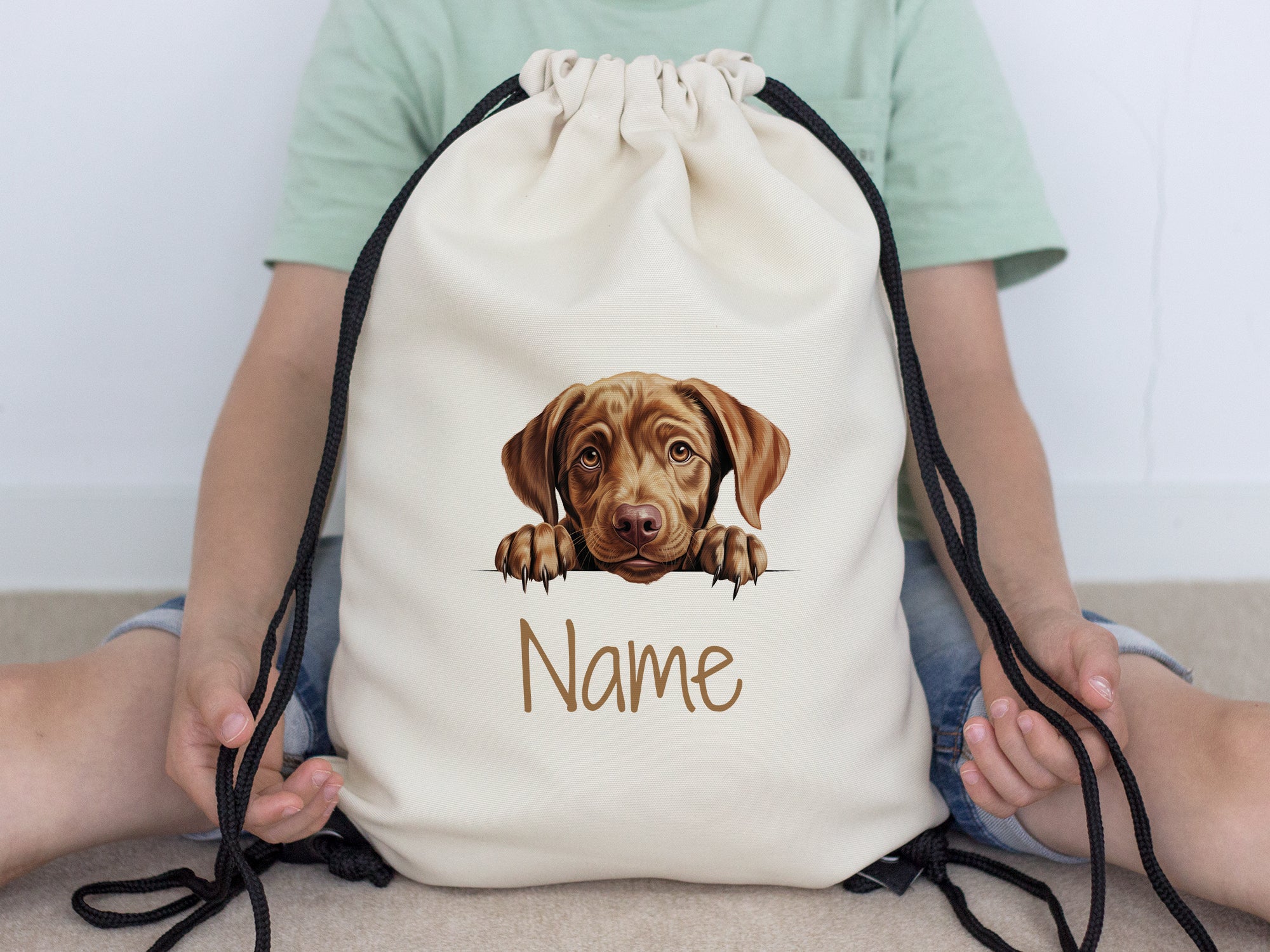 Beige Turnbeutel mit Hundemotiv und personalisierbarem Namen.