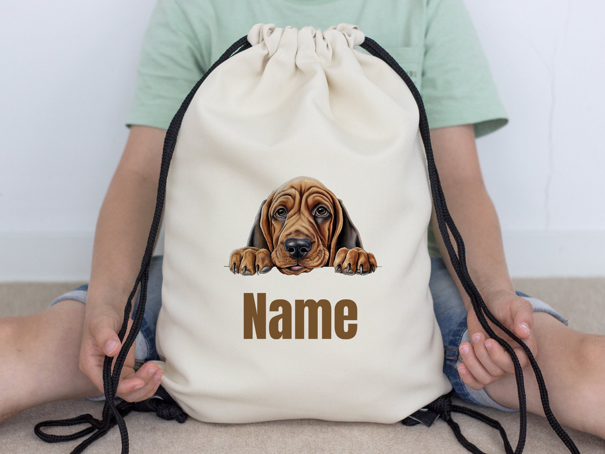 Beige Turnbeutel mit Hundemotiv und personalisierbarem Namen.