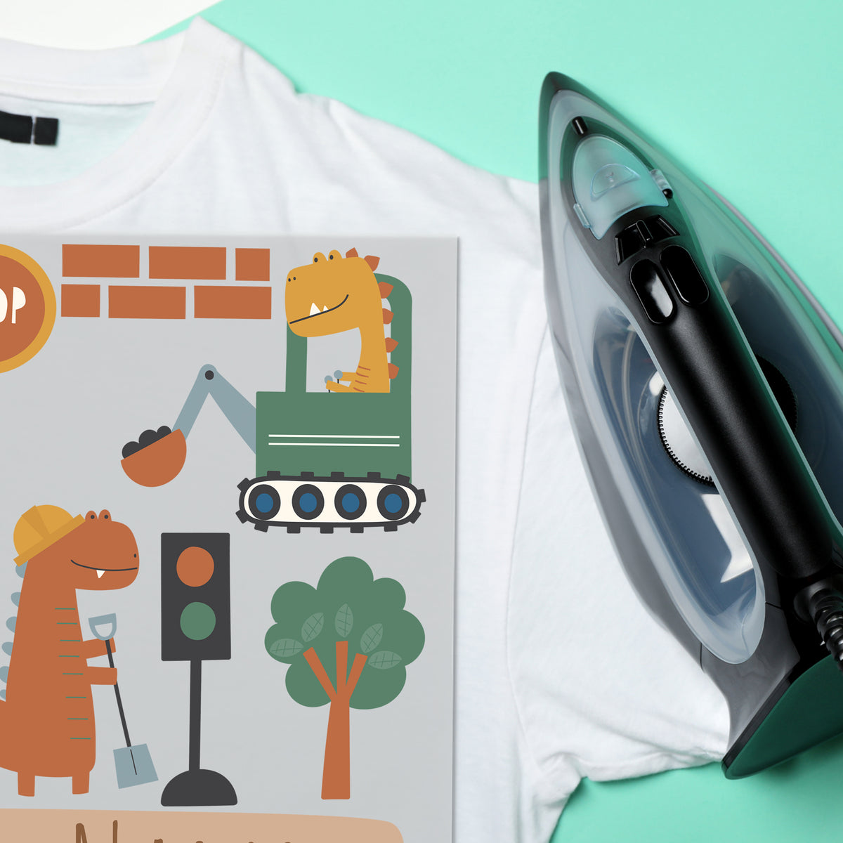 Weißes T-Shirt mit buntem Dinosaurier-Motiv und Dampfbügeleisen.