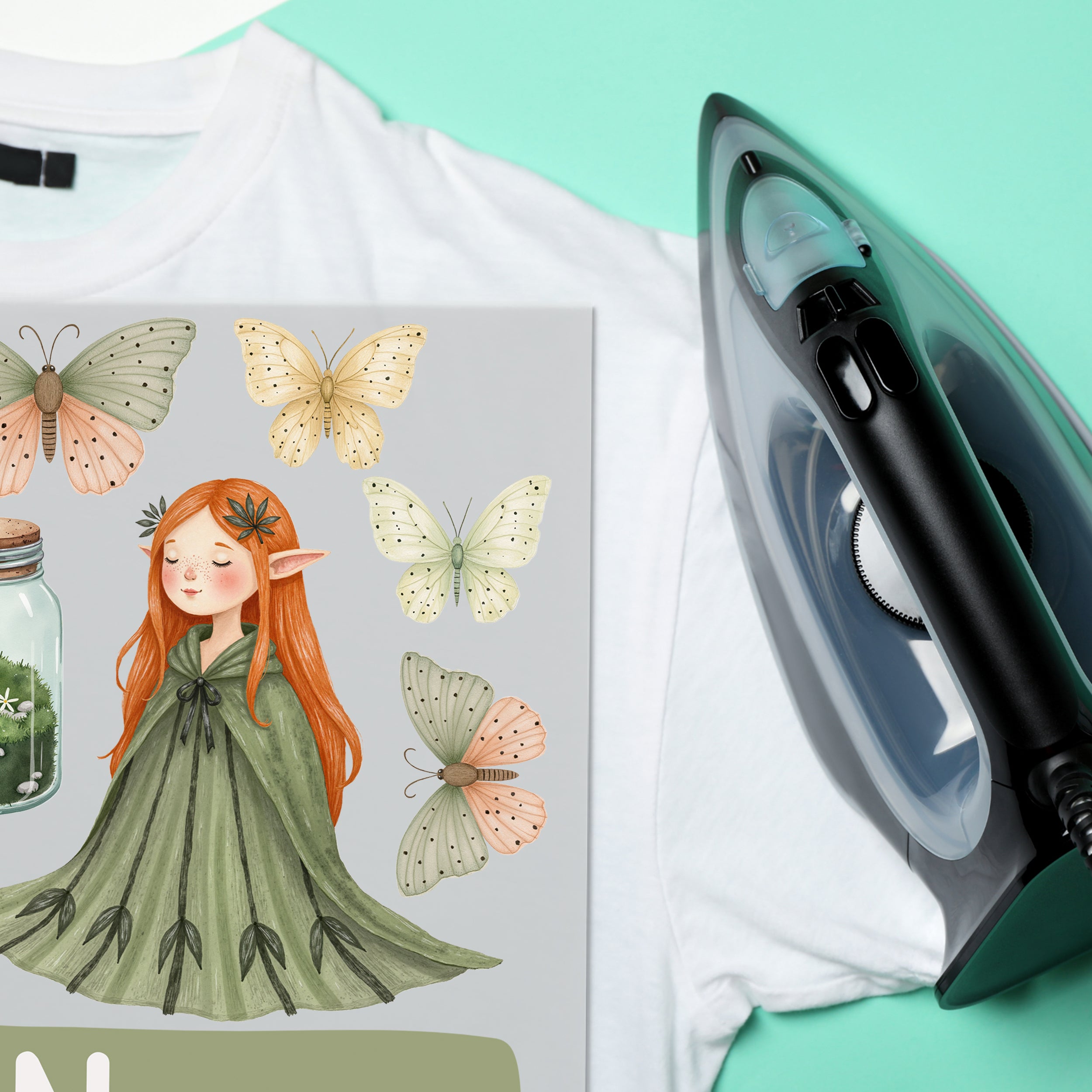 T-Shirt mit Elfenmotiv, grüner Umhang und Schmetterlingen.