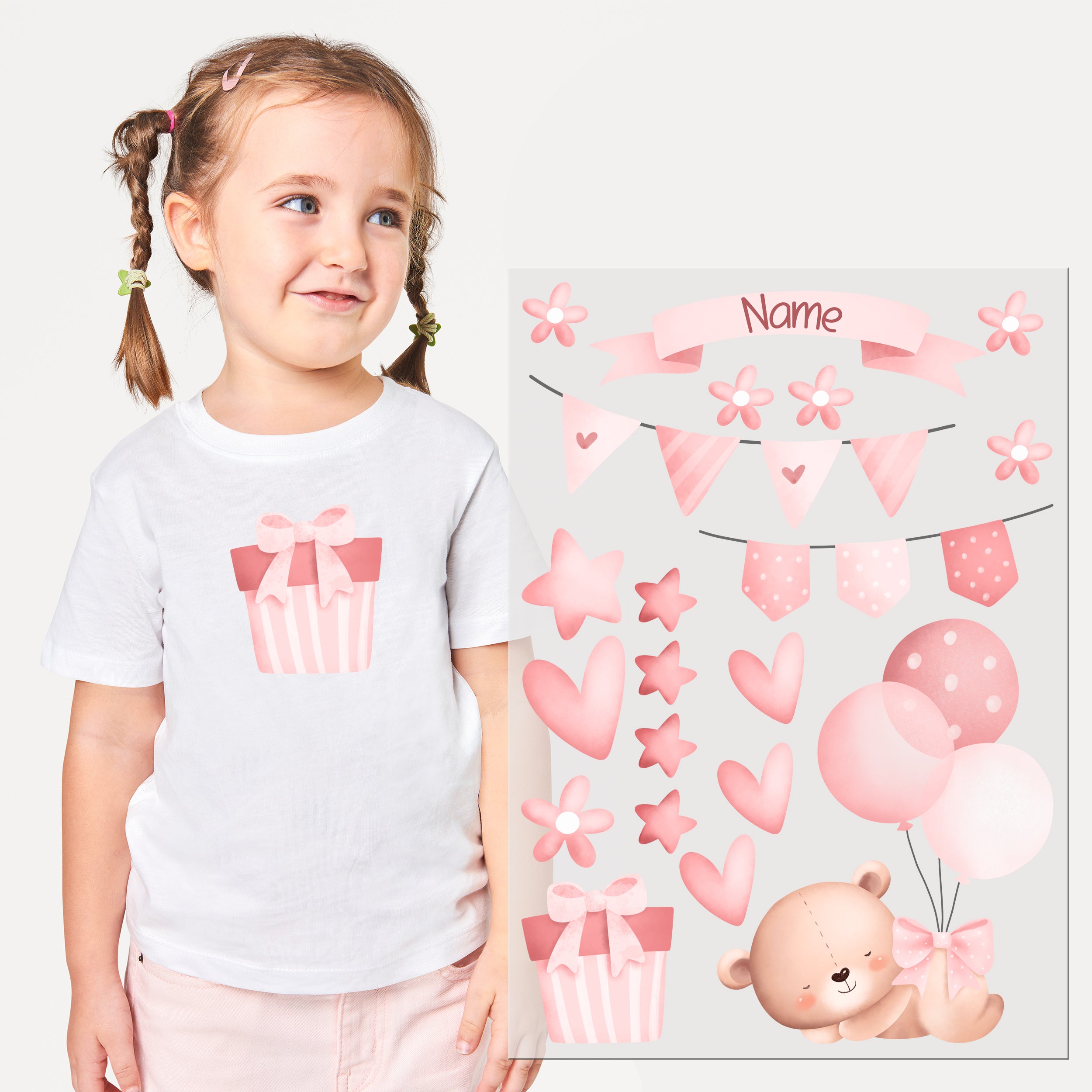 Weißes T-Shirt mit rosa Geschenkdesign und bunten Dekorationen.
