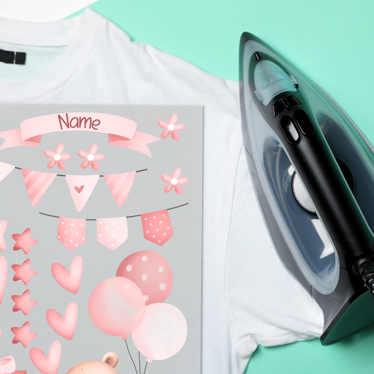 Weißes T-Shirt mit rosa Aufklebern und Dampfbügeleisen.