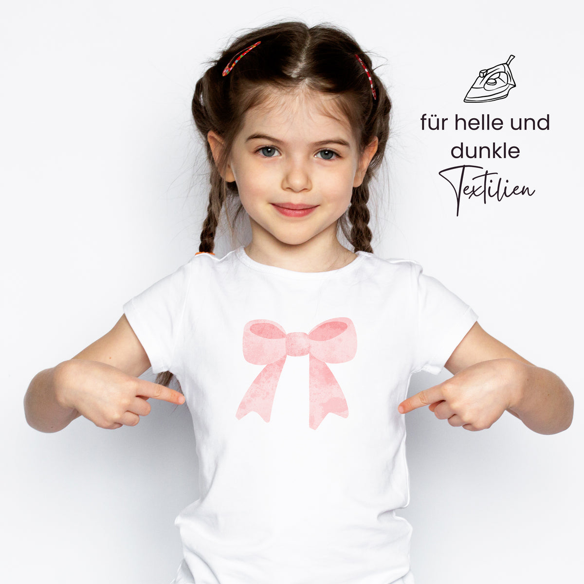 Weißes T-Shirt mit pinkem Schleifenmotiv.