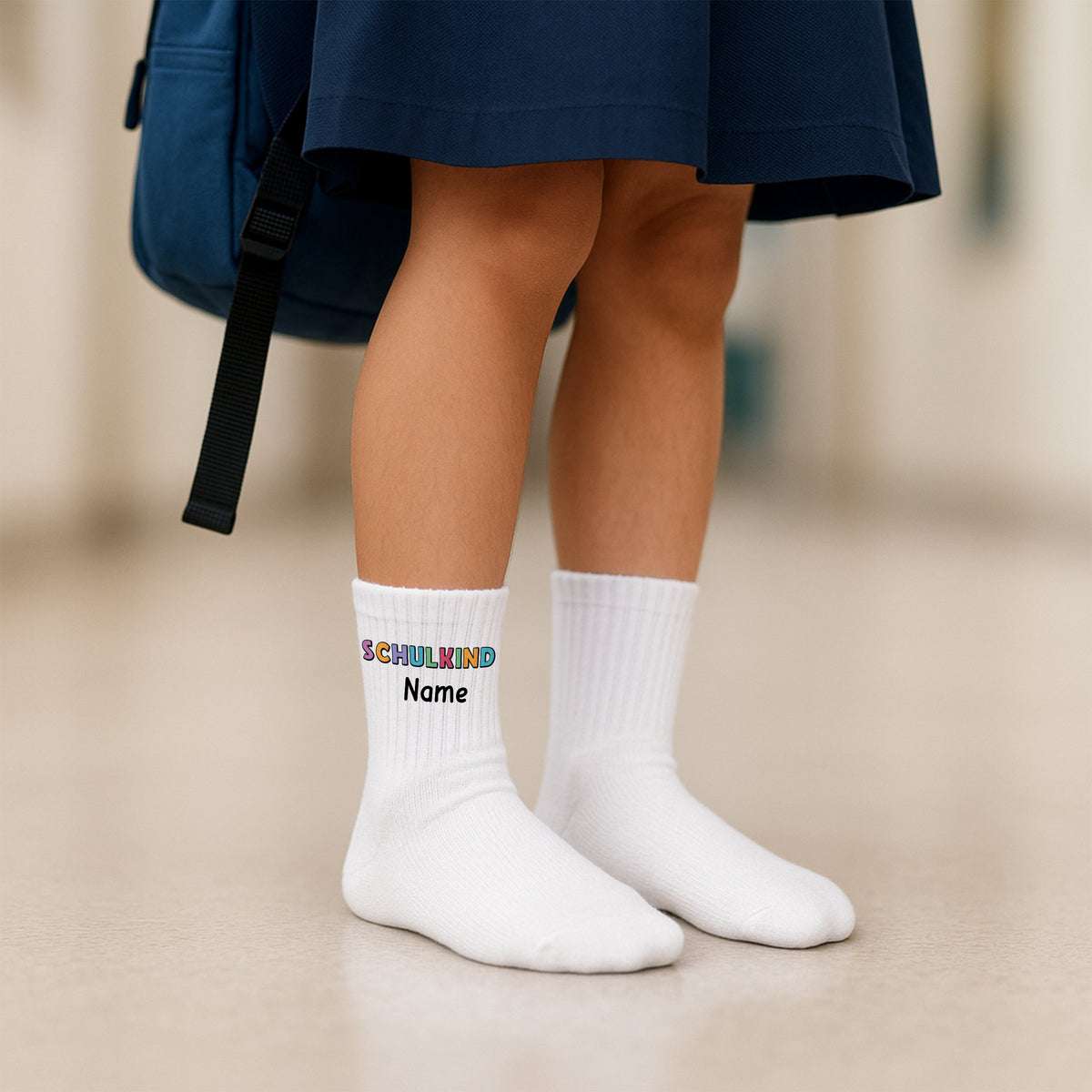 Weiße Socken mit buntem Aufdruck "SCHULKIND" und Platz für Namen.
