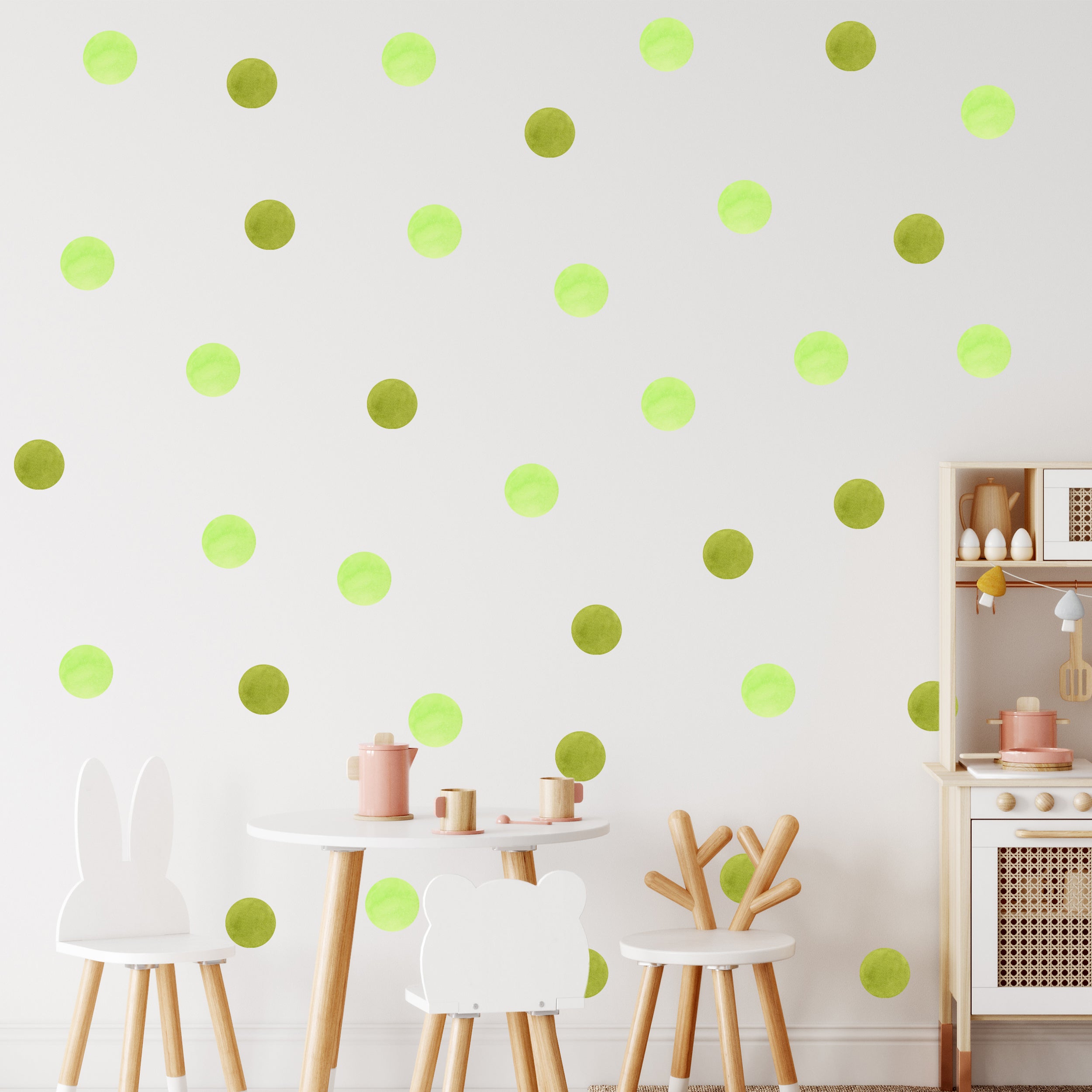 Grüne Punkte auf weißer Wand mit Kindermöbeln.