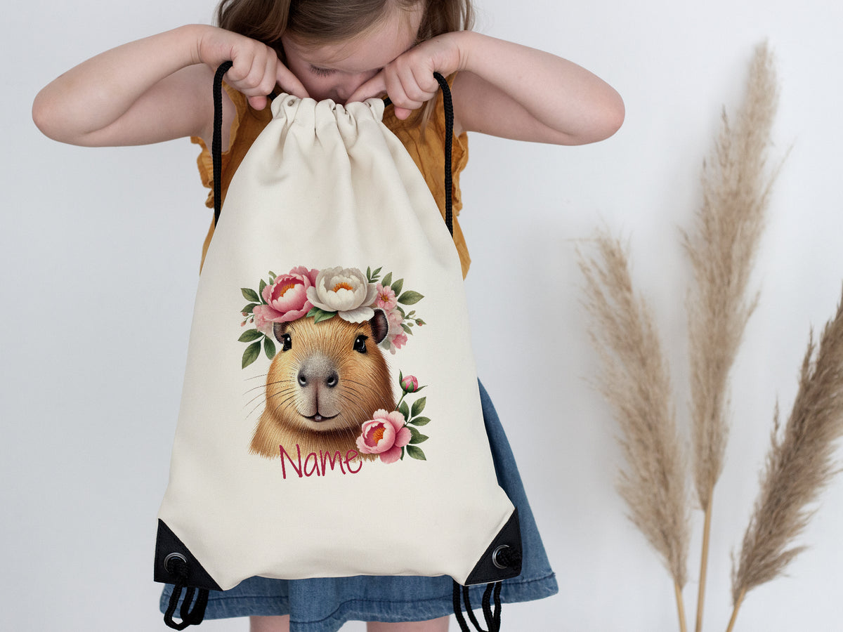 Beige Turnbeutel mit Meerschweinchen-Motiv und Blumen.
