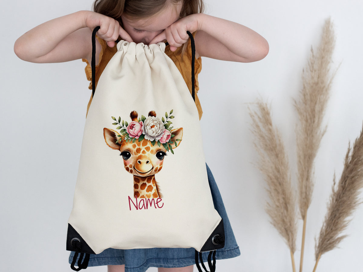 Beige Turnbeutel mit Giraffenmotiv und Blumenkranz.