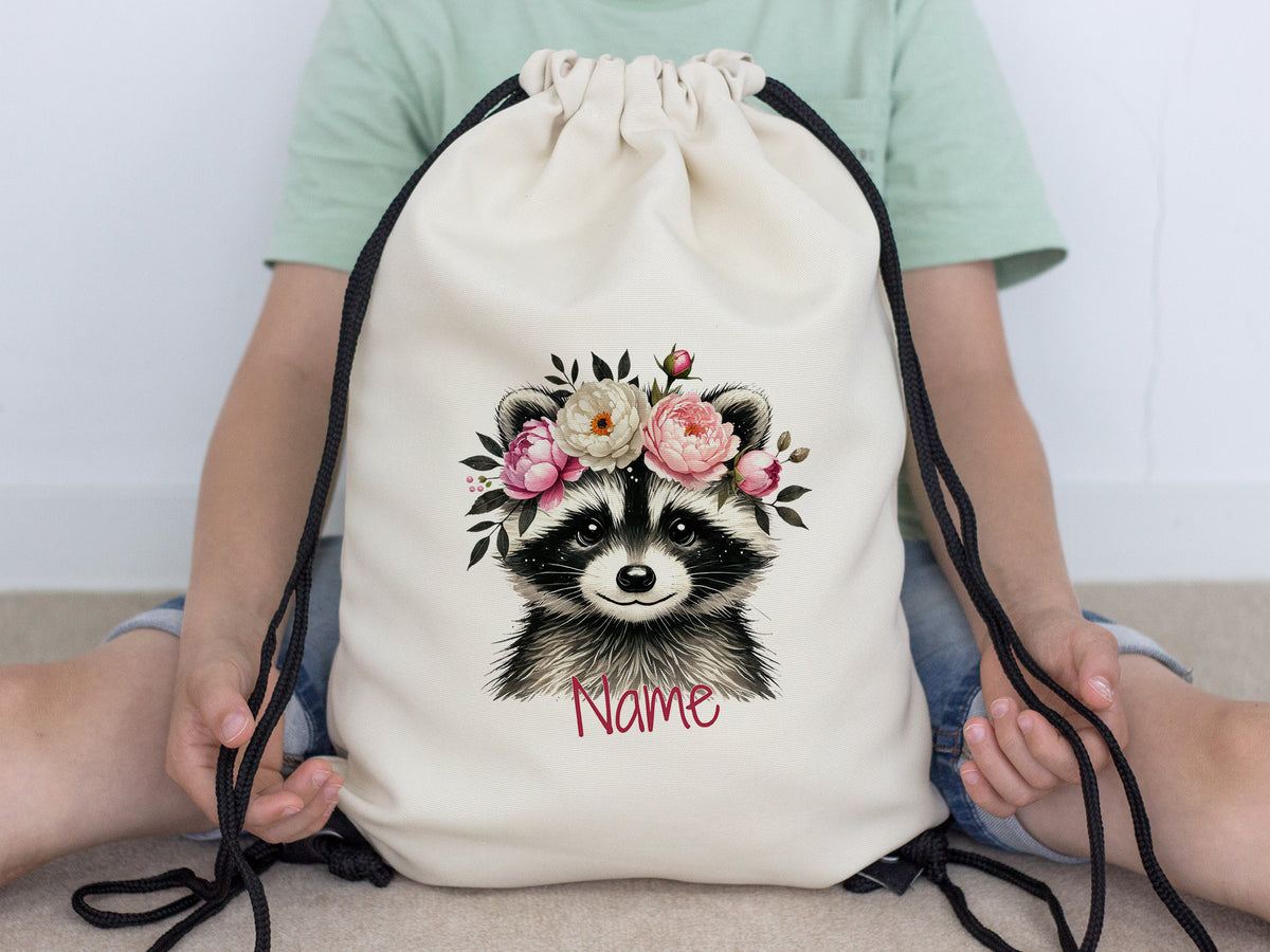 Beiger Turnbeutel mit Waschbär und Blumenmotiv.