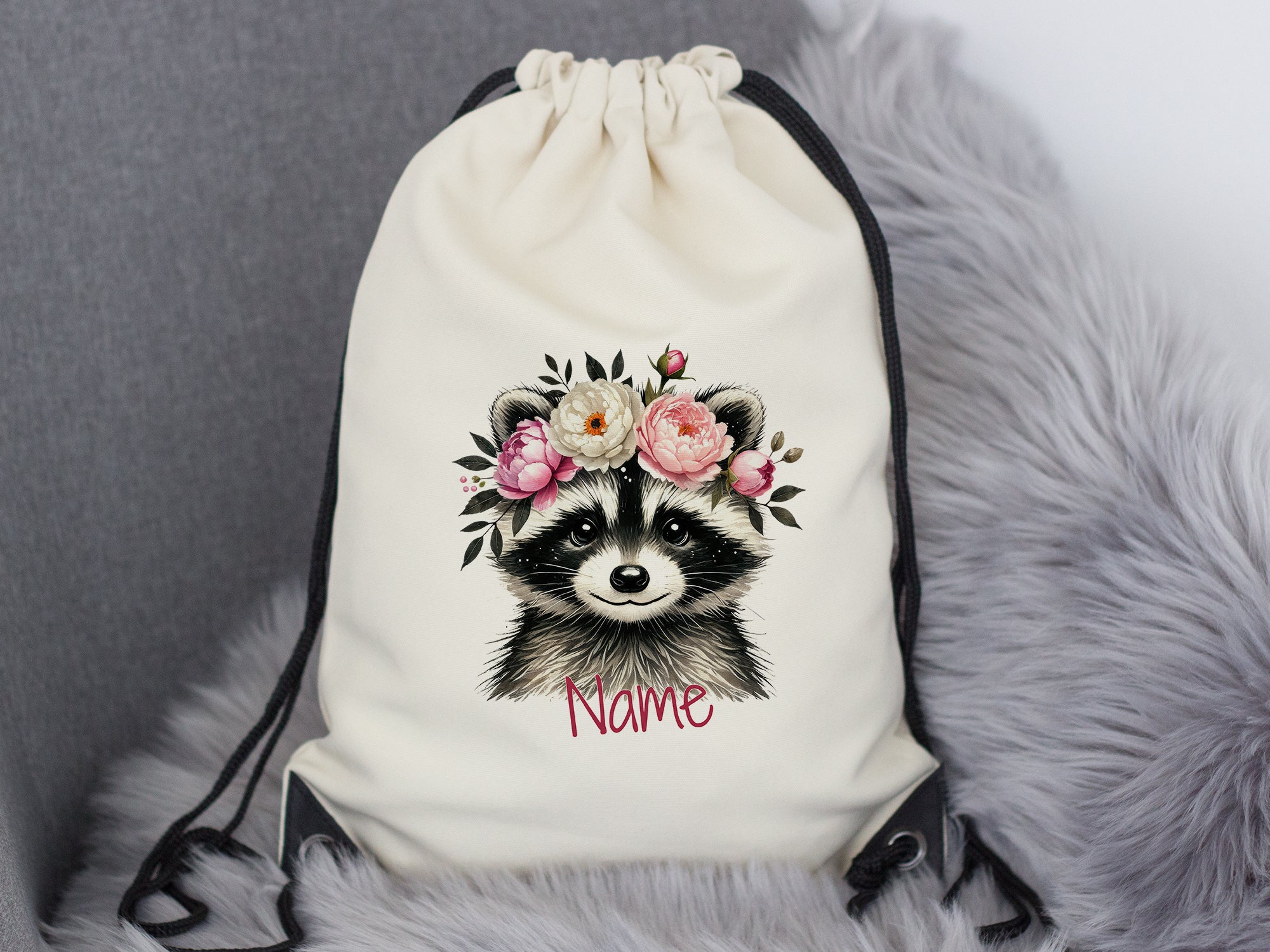 Beige Turnbeutel mit Waschbär und Blumenmotiv.