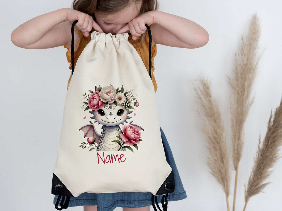 Beige Turnbeutel mit niedlichem Drachen und Blumenmotiv.