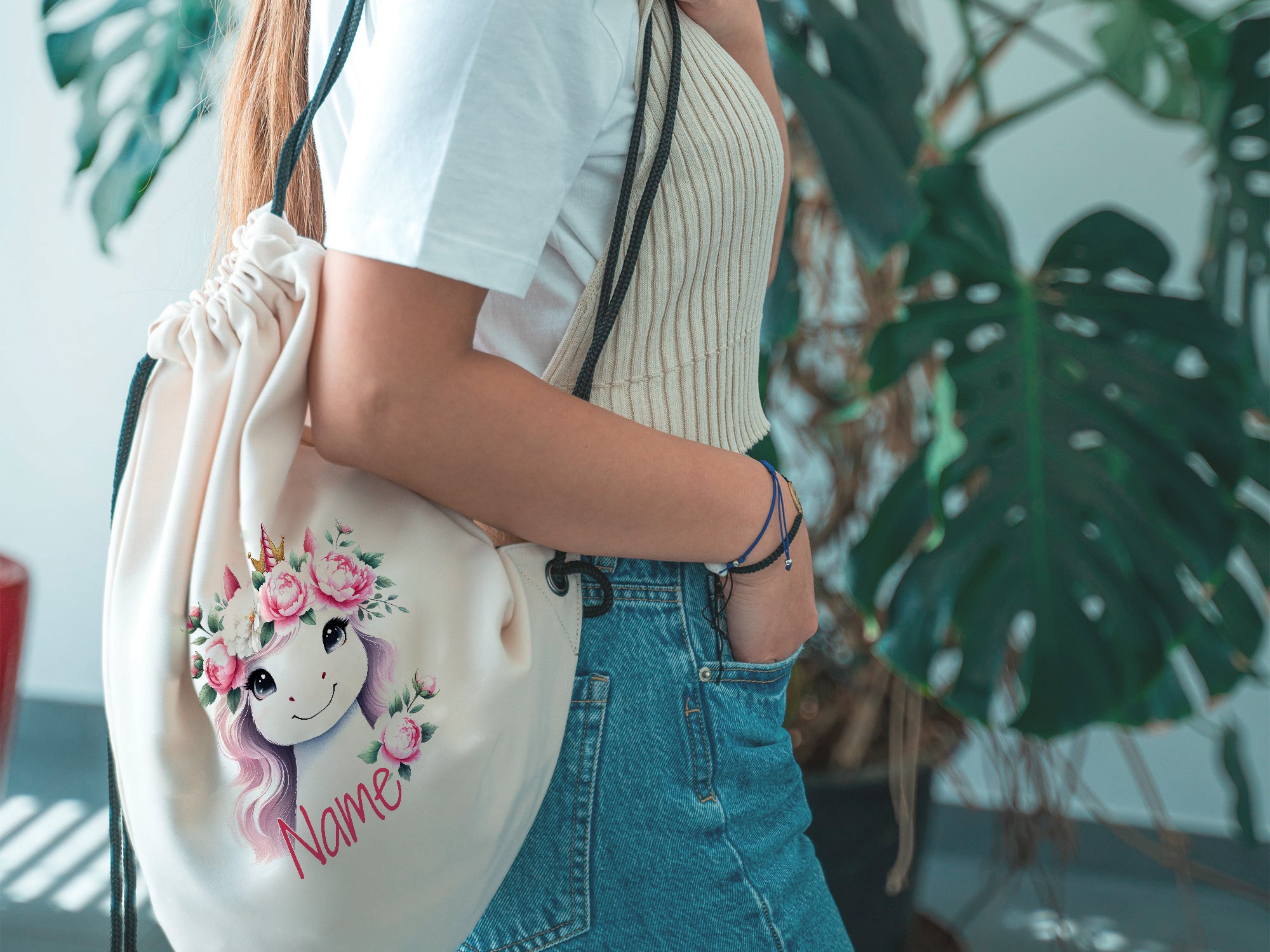 Beige Turnbeutel mit Einhorn und Blumenmotiv.