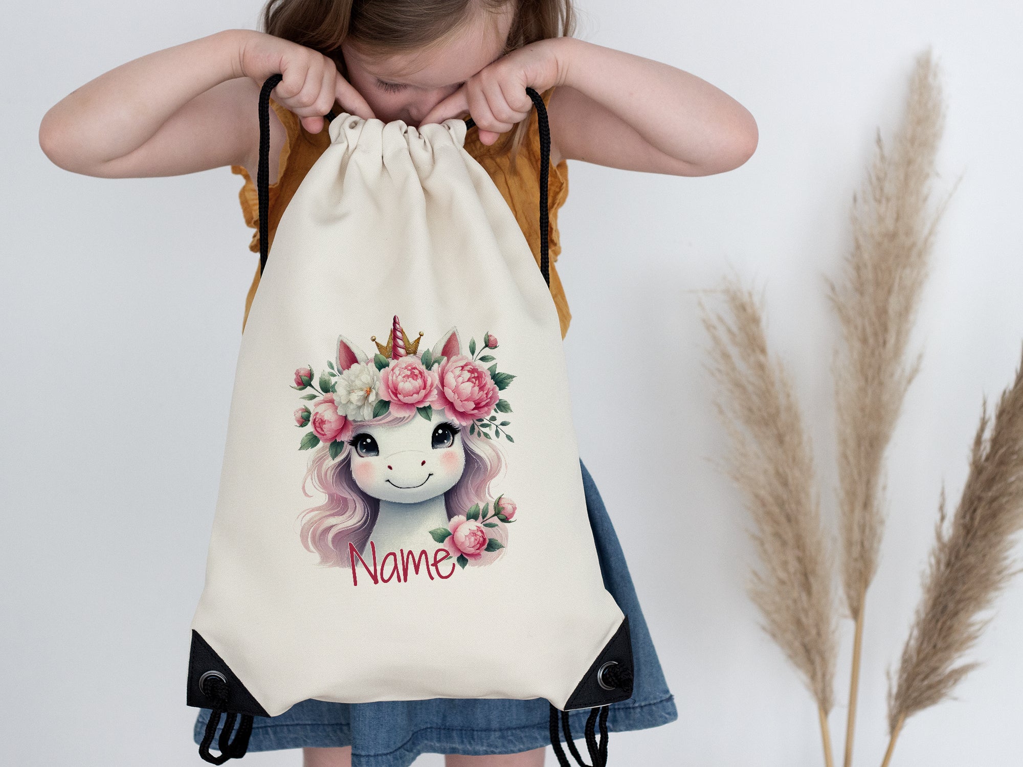 Beige Turnbeutel mit Einhorn-Motiv und Blumenkranz.