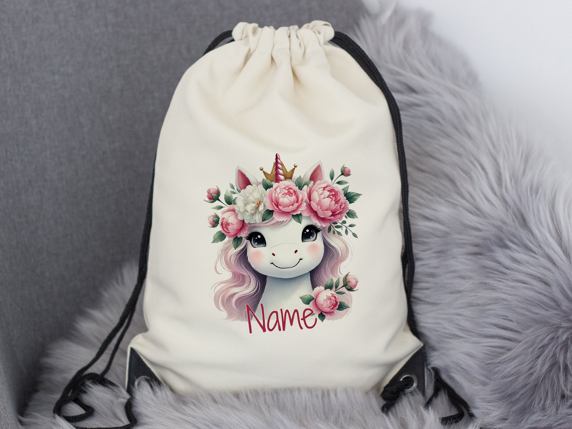 Beige Turnbeutel mit Einhorn und Blumenmotiv.