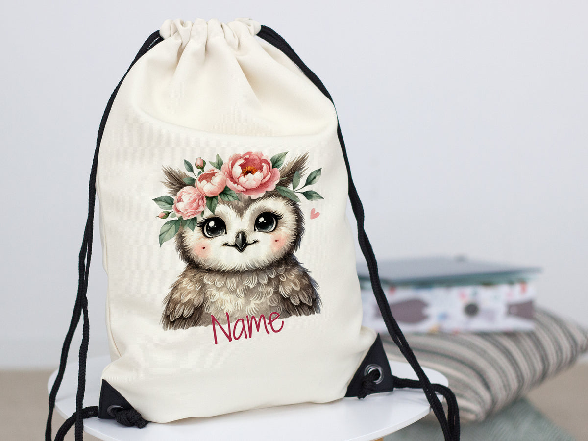 Beige Turnbeutel mit Eule und Blumenmotiv.