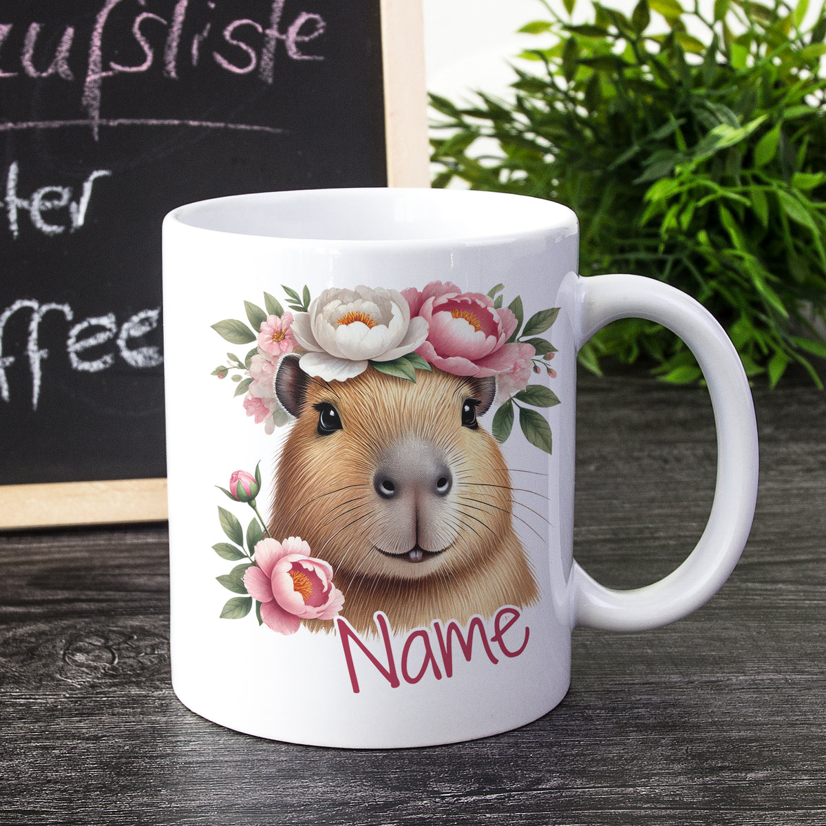Weißer Becher mit Capybara-Illustration und Blumen.
