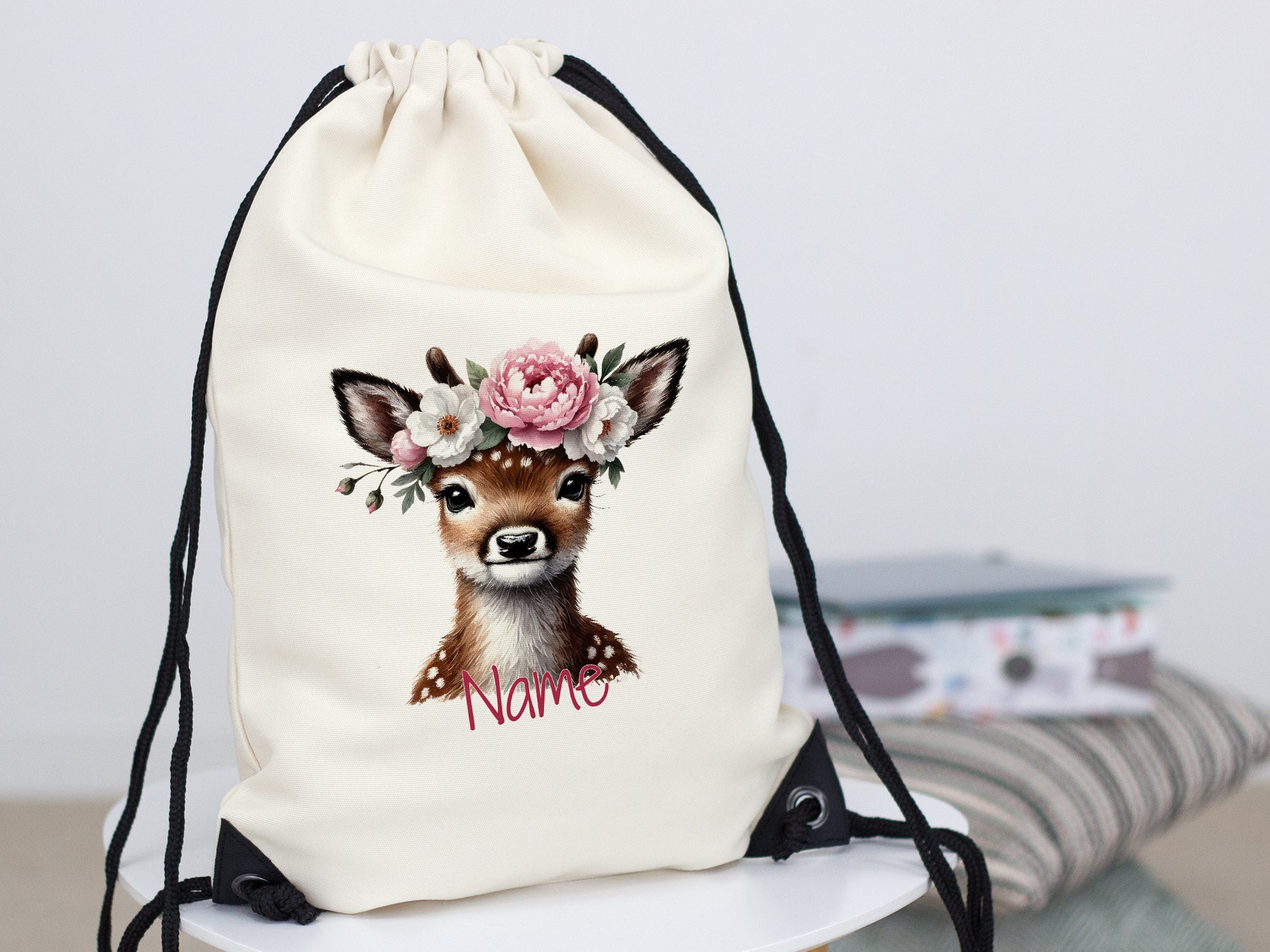 Beige Turnbeutel mit Reh-Motiv und Blumenkranz.