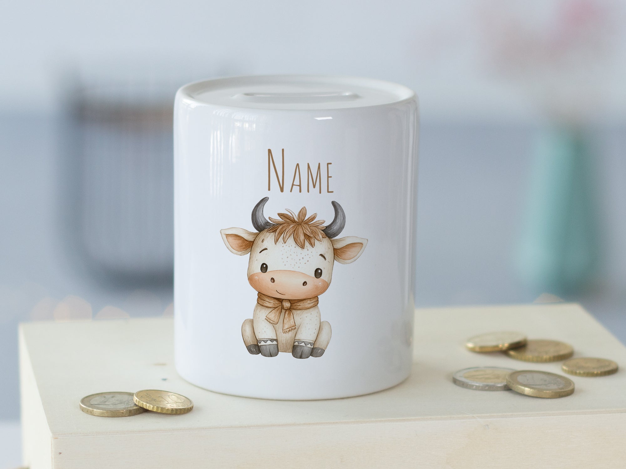 Weißes Sparschwein mit niedlichem Kuh-Design und Platz für Namen.