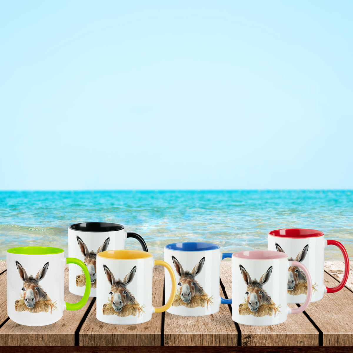 Bunte Tassen mit Eselmotiven am Strand.