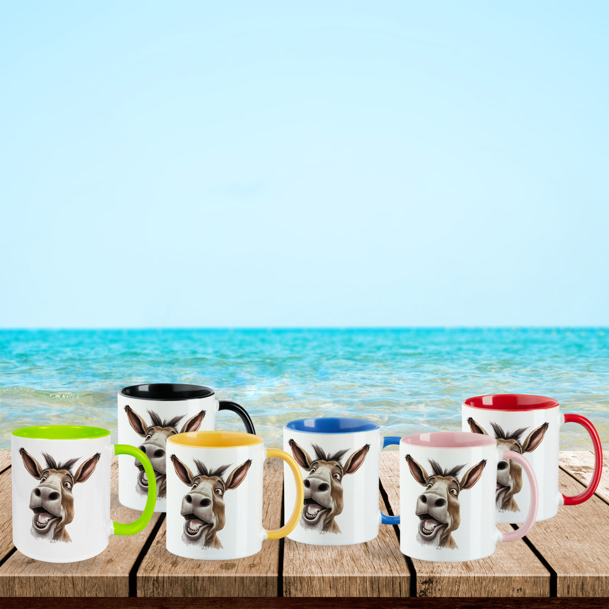 Bunte Tassen mit Esel-Motiv am Strand.