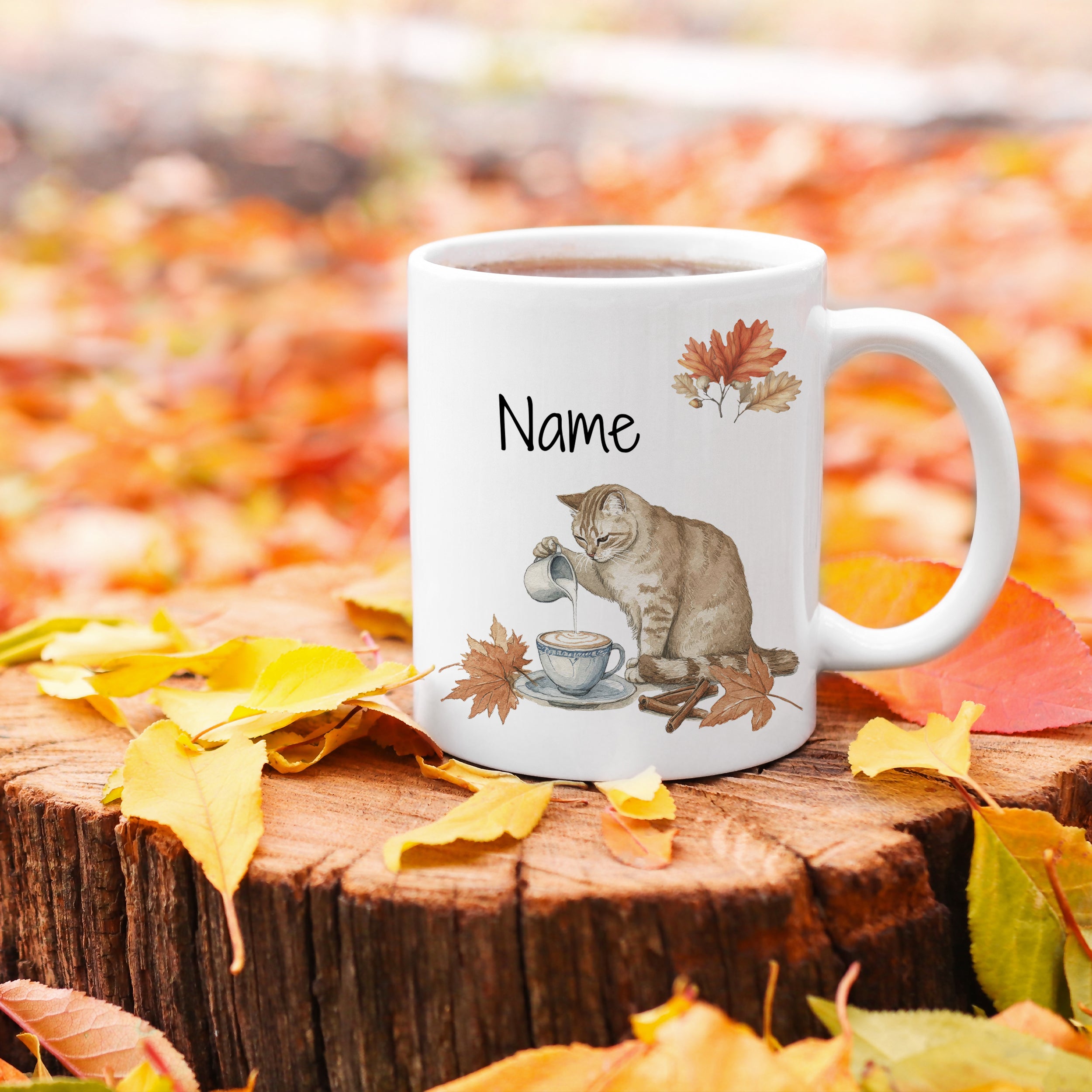 Weißer Kaffeebecher mit Katze und Herbstblättern.
