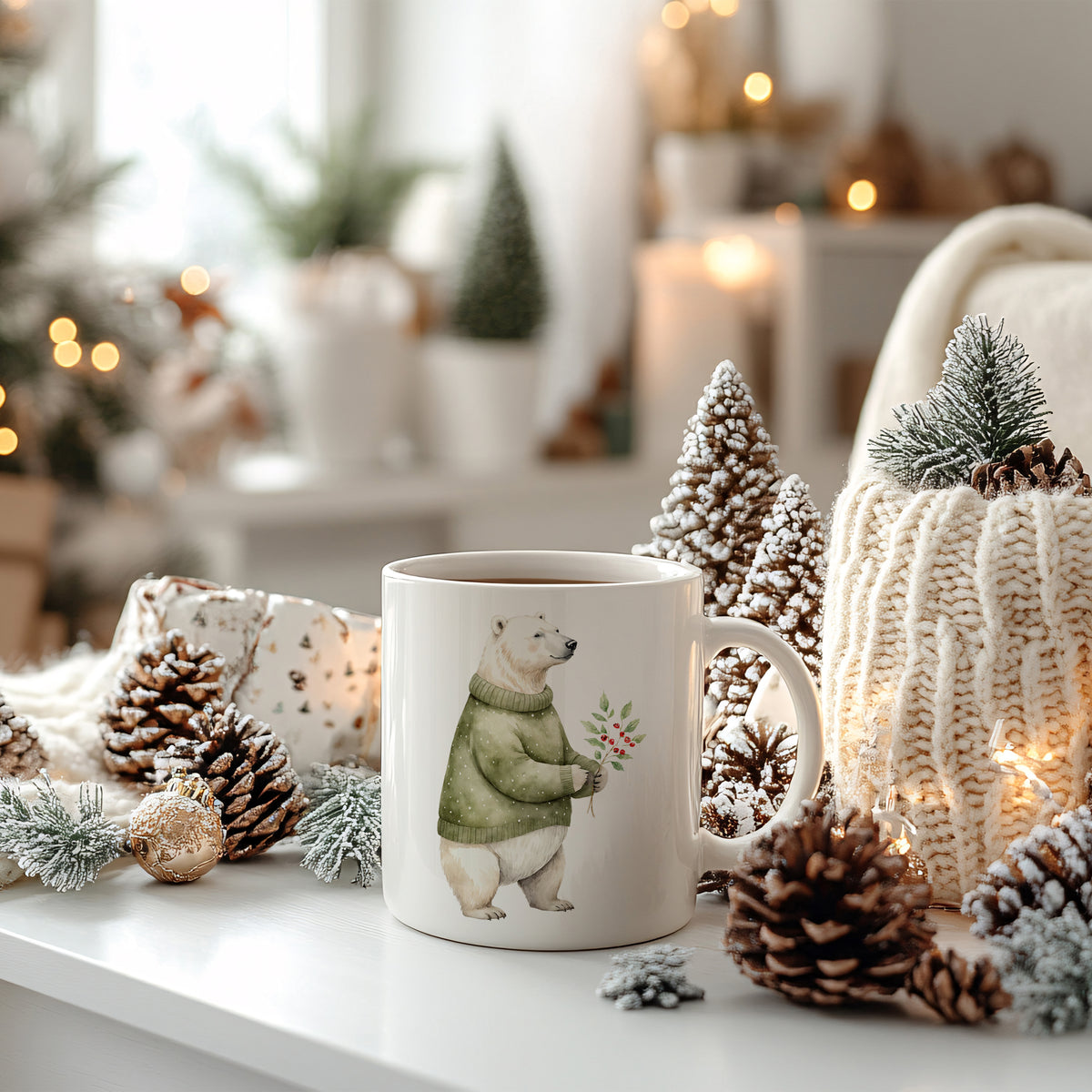 Tasse mit Bärenmotiv, grünem Pullover, winterlicher Dekoration.