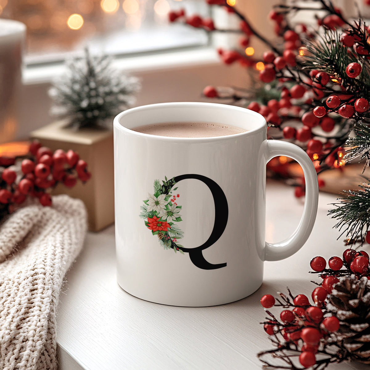 Weißer Becher mit floralem "Q"-Design und heißem Getränk.