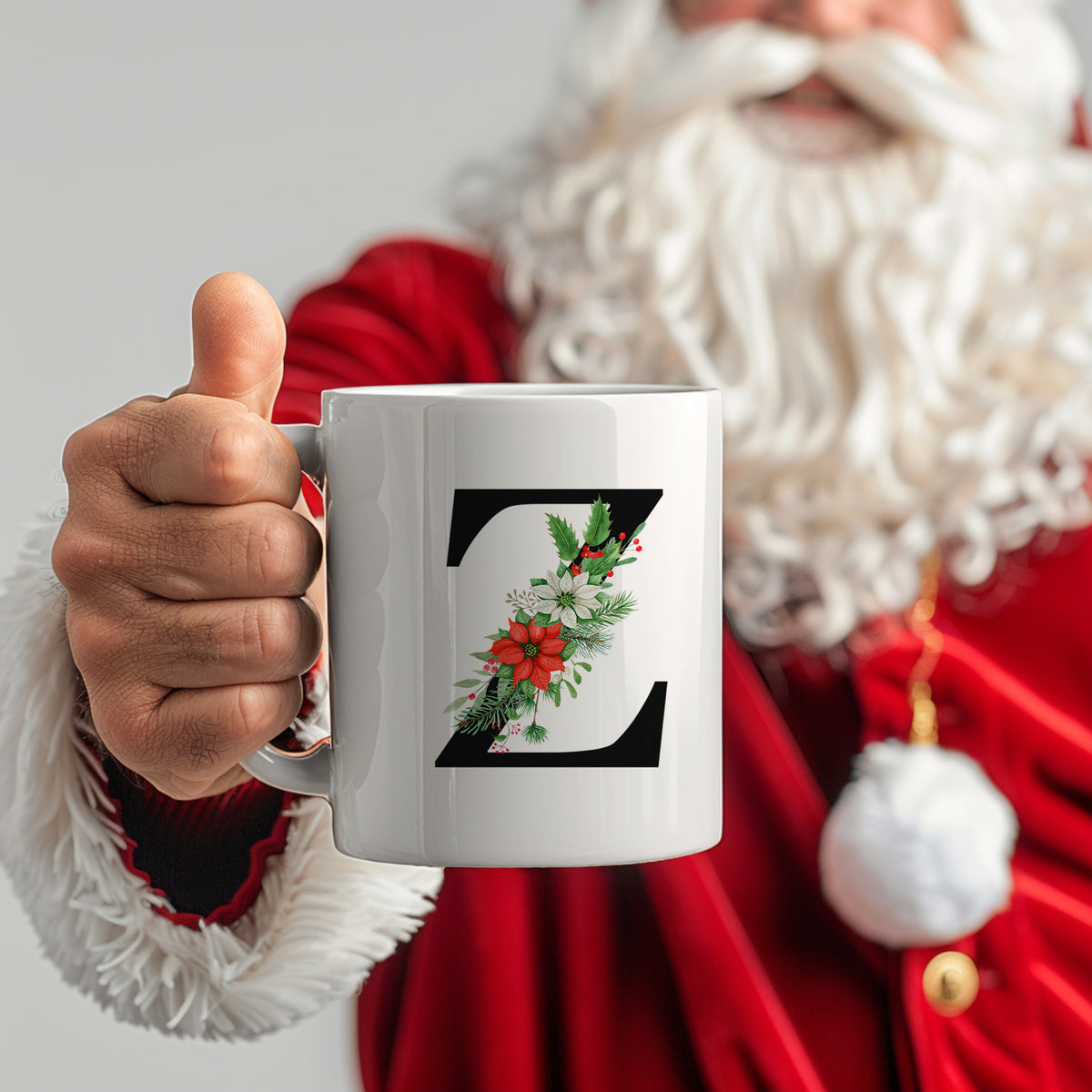 Weißer Becher mit floralem Z-Motiv und Weihnachtsdekor.