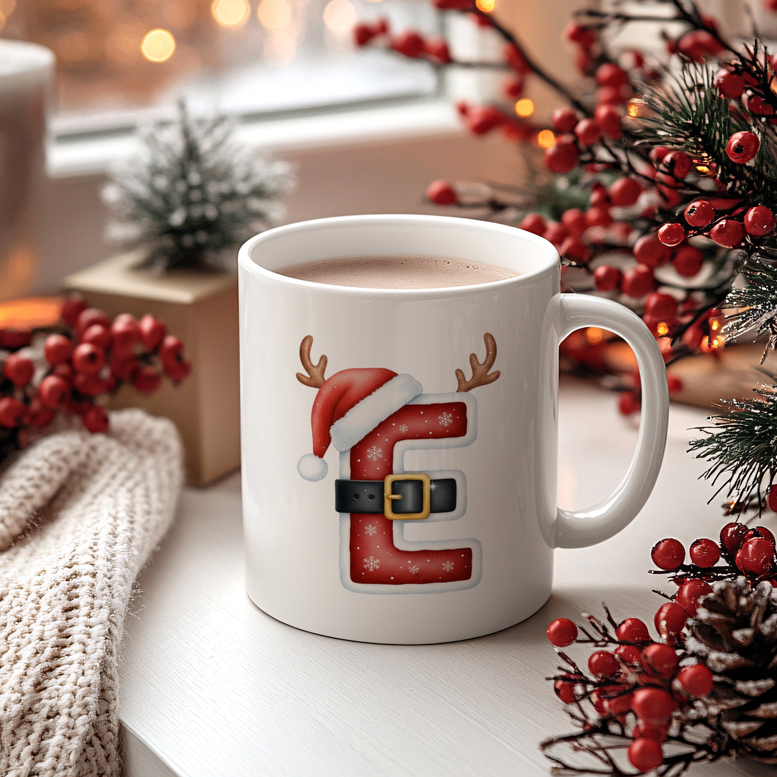Weißer Becher mit Weihnachtsmotiv, roter Buchstabe E, Schnee.