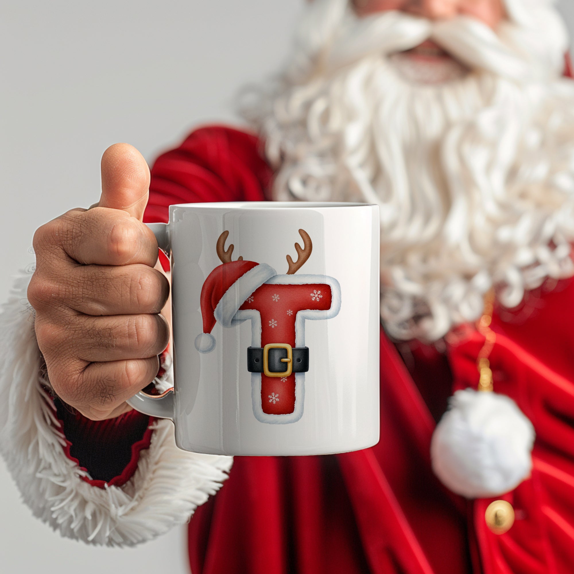 Weißer Becher mit rotem Weihnachtsmotiv und Buchstaben T.