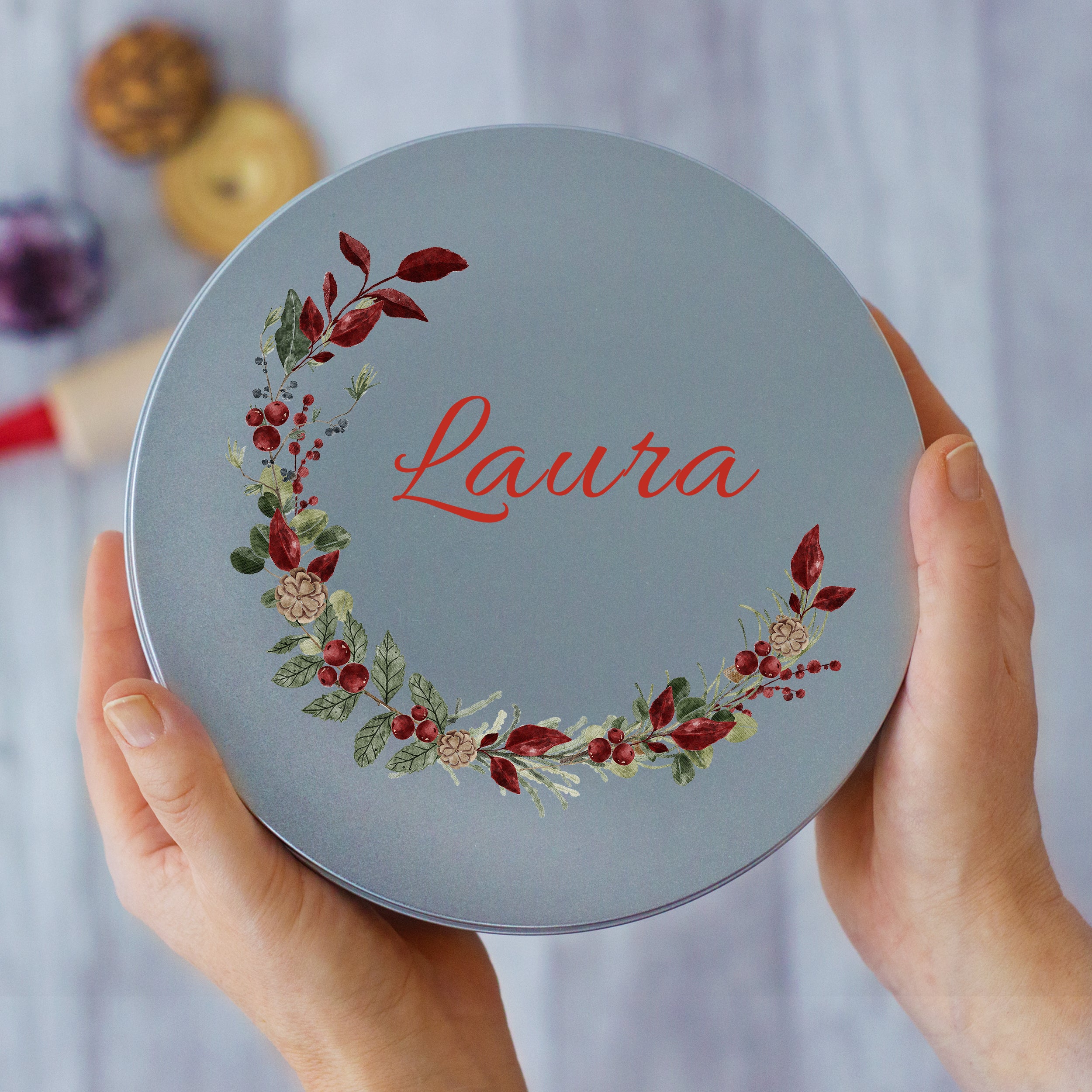 Runde, graue Dose mit floralem Design und Namen "Laura".