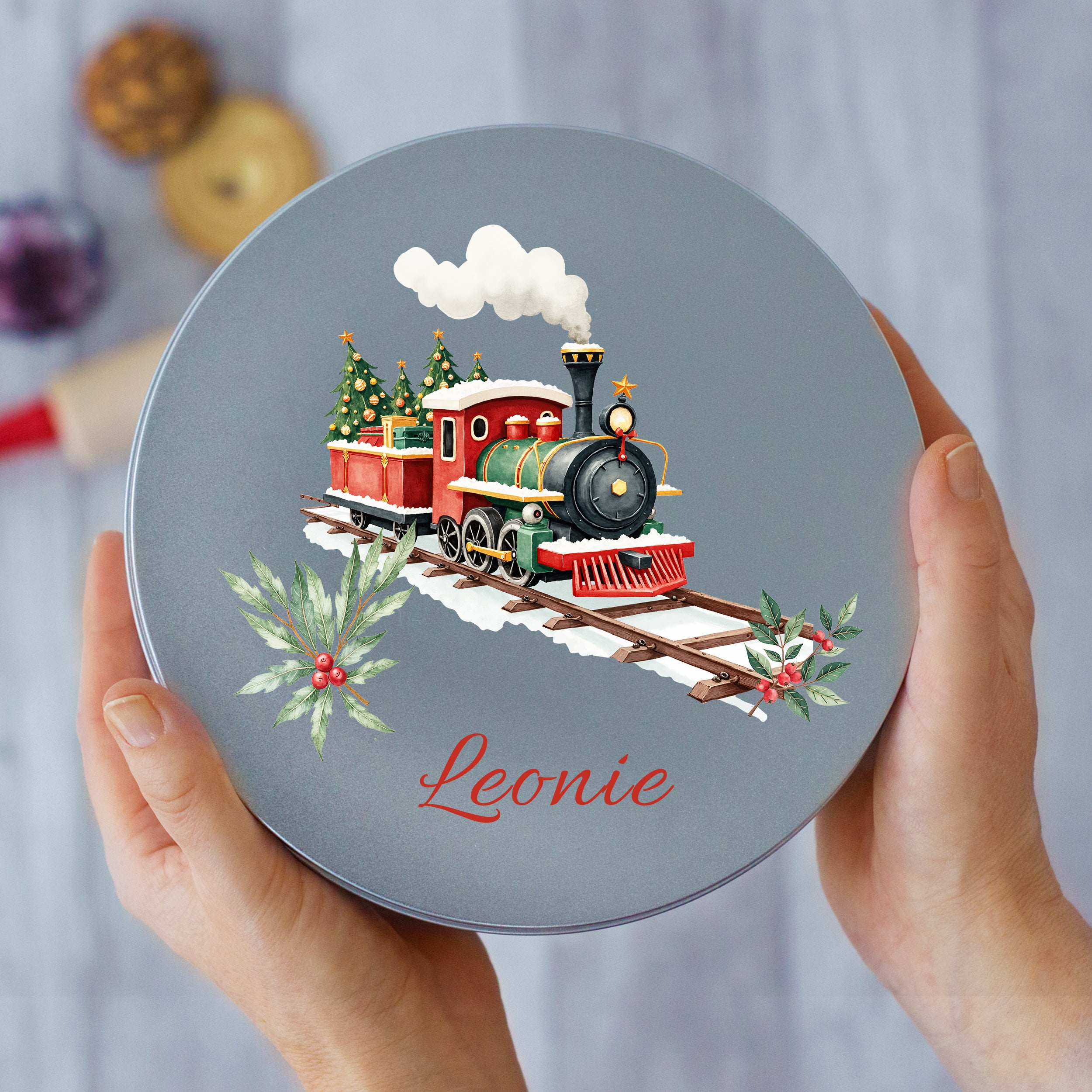 Runde, graue Dose mit Weihnachtszug und personalisiertem Namen.