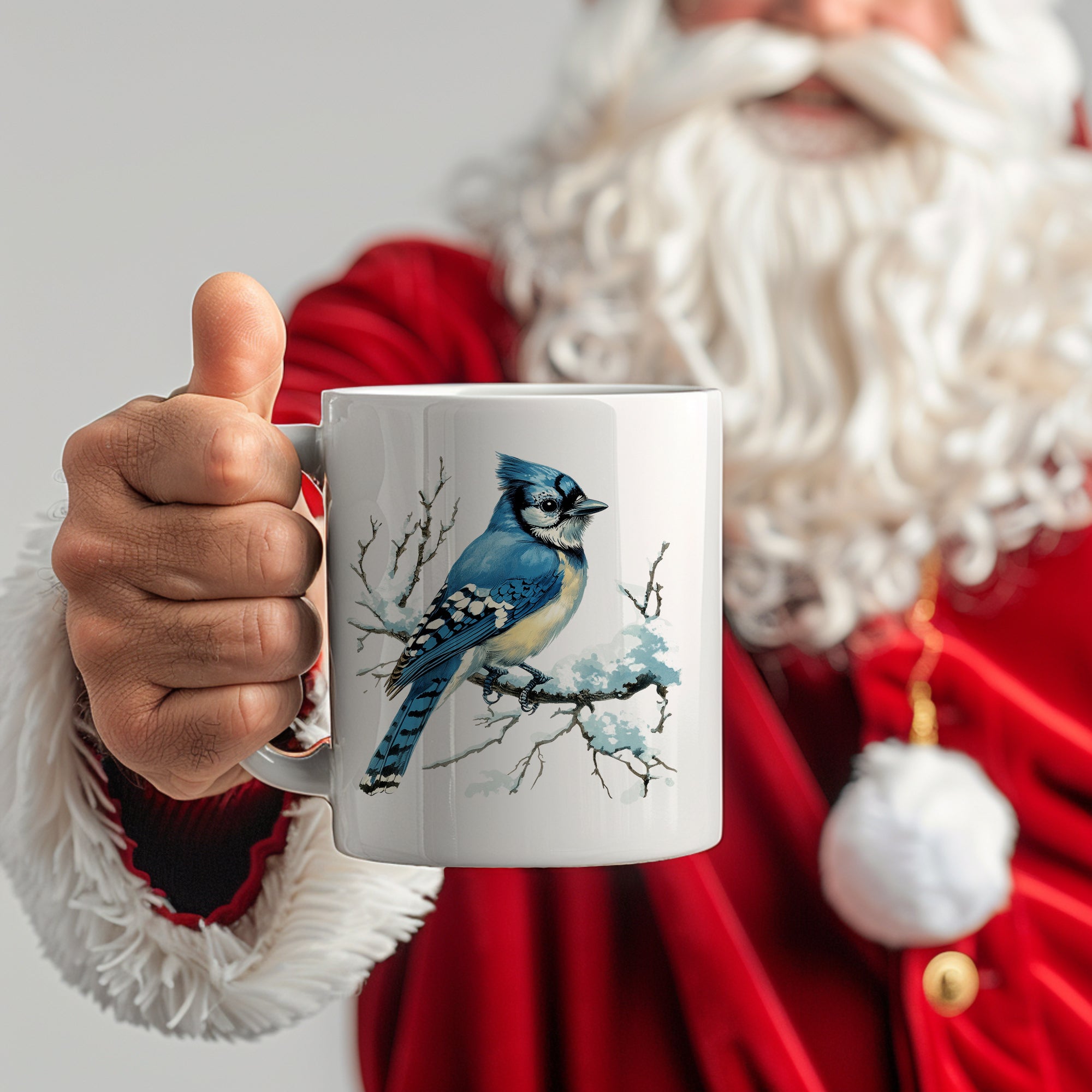 Weißer Kaffeebecher mit blauem Vogelmotiv, gehalten von einem Weihnachtsmann.