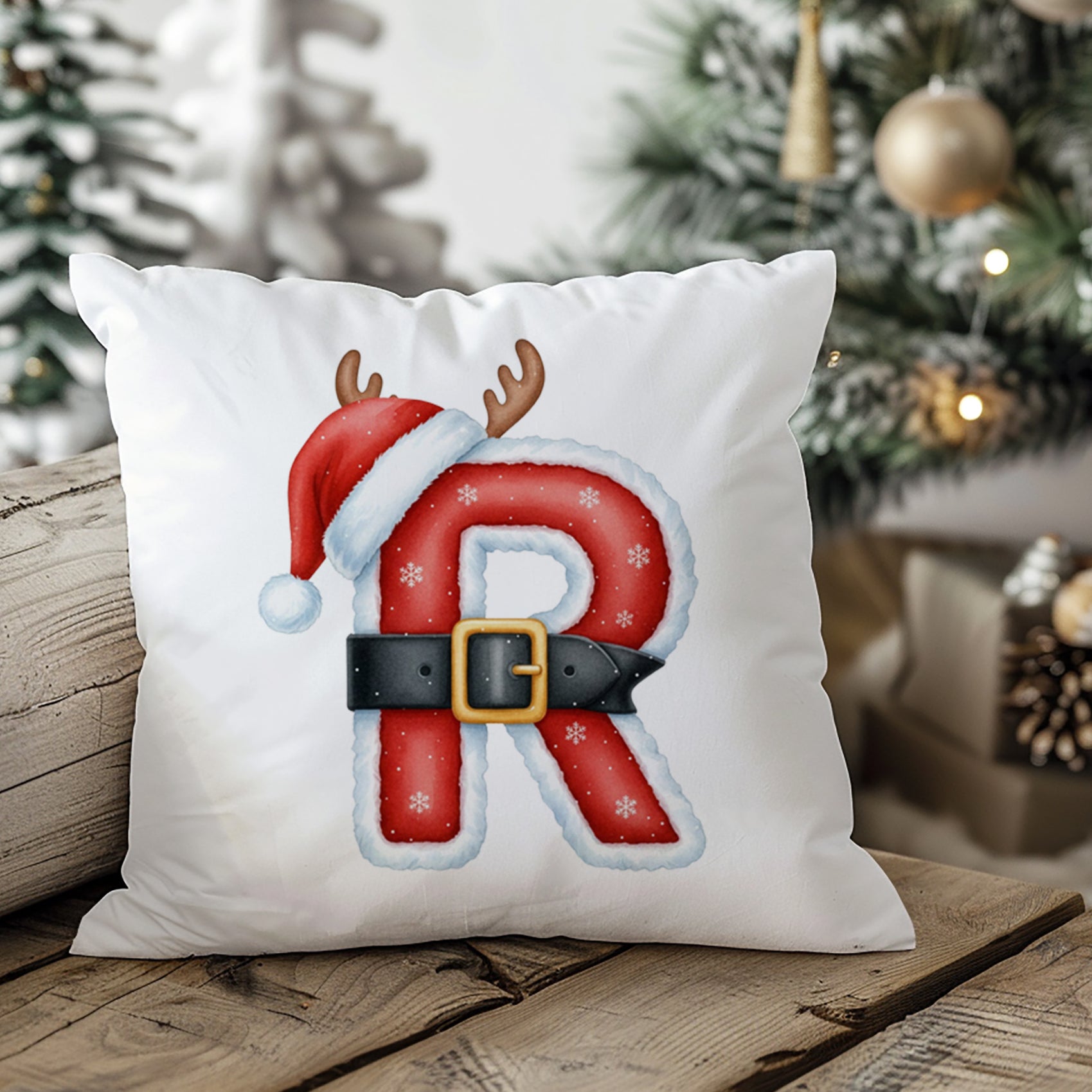 Weißes Kissen mit rotem Weihnachtsbuchstaben R, Weihnachtsmütze und Geweih.