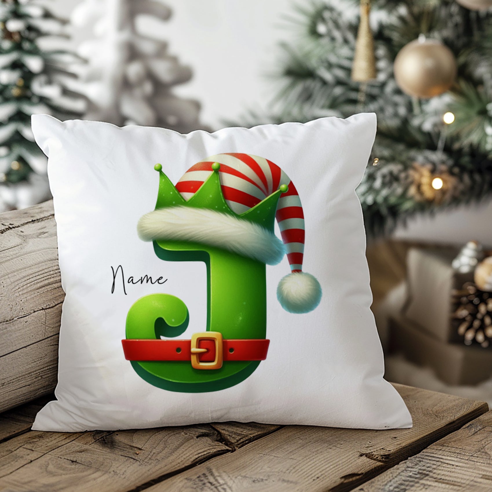 Weihnachtliches Kissen mit grünem Buchstaben J und Hut.