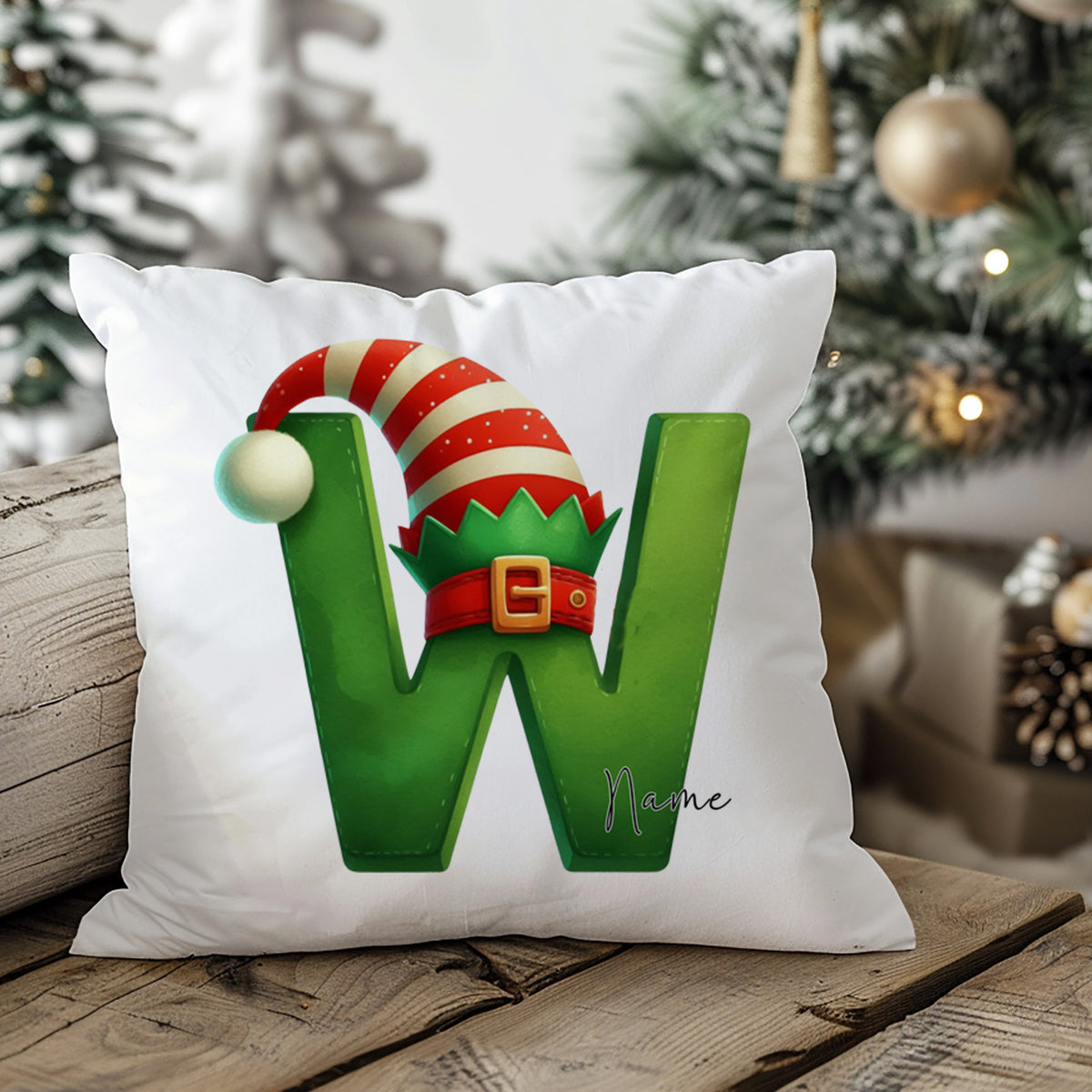 Grünes Kissen mit dem Buchstaben W und Weihnachtsmütze.