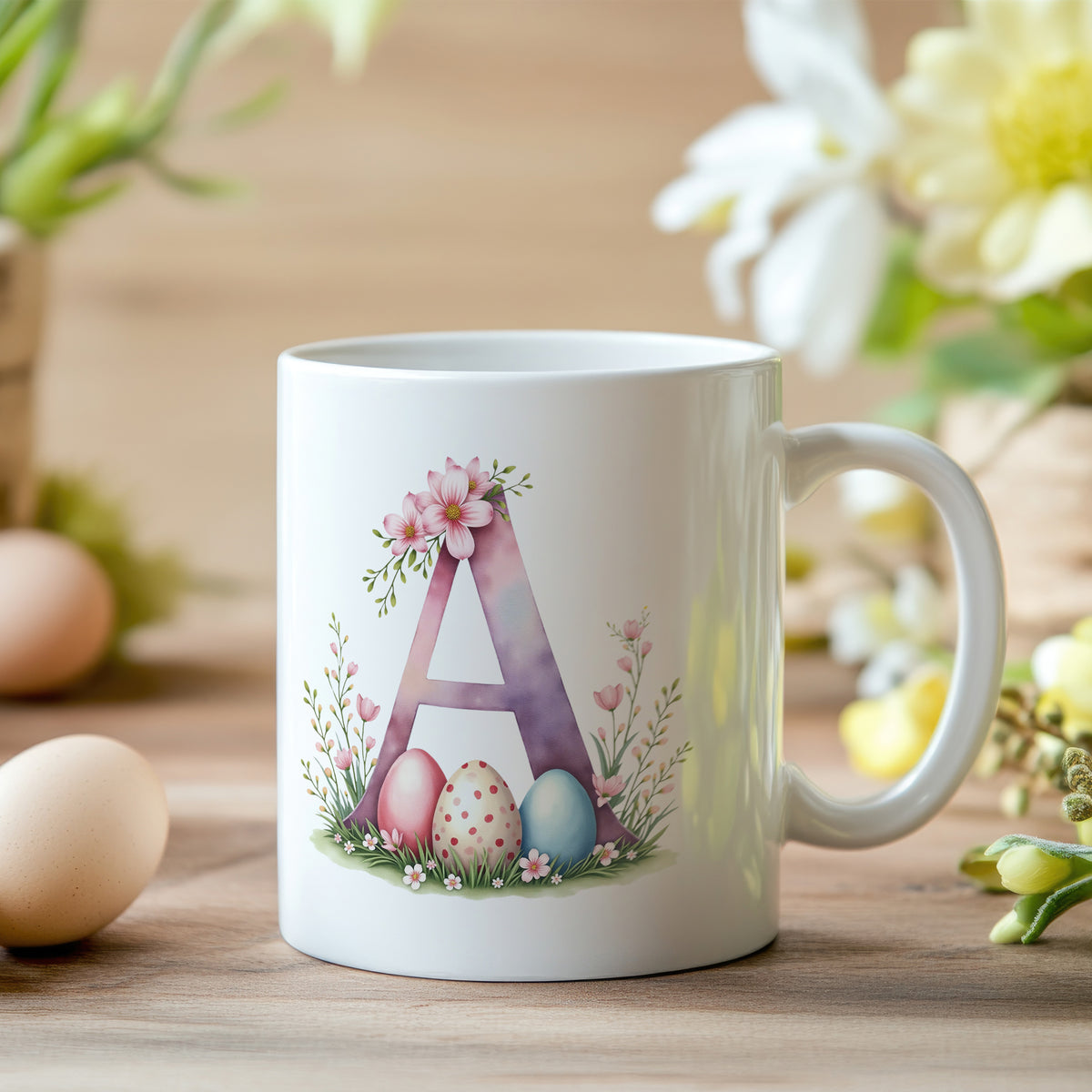Tasse mit floralem "A", bunten Ostereiern und Blumen.