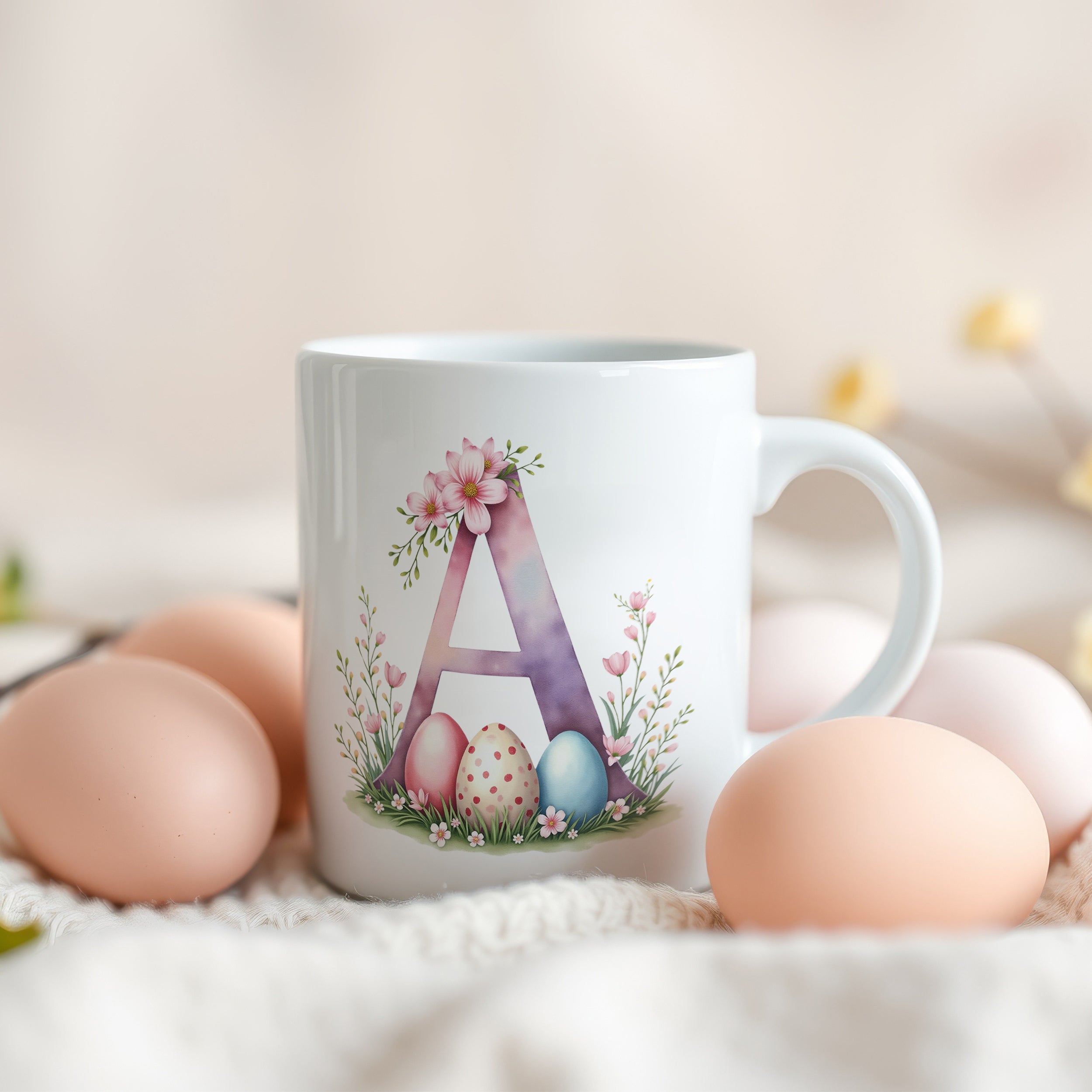 Weiße Tasse mit floralem A und bunten Ostereiern.