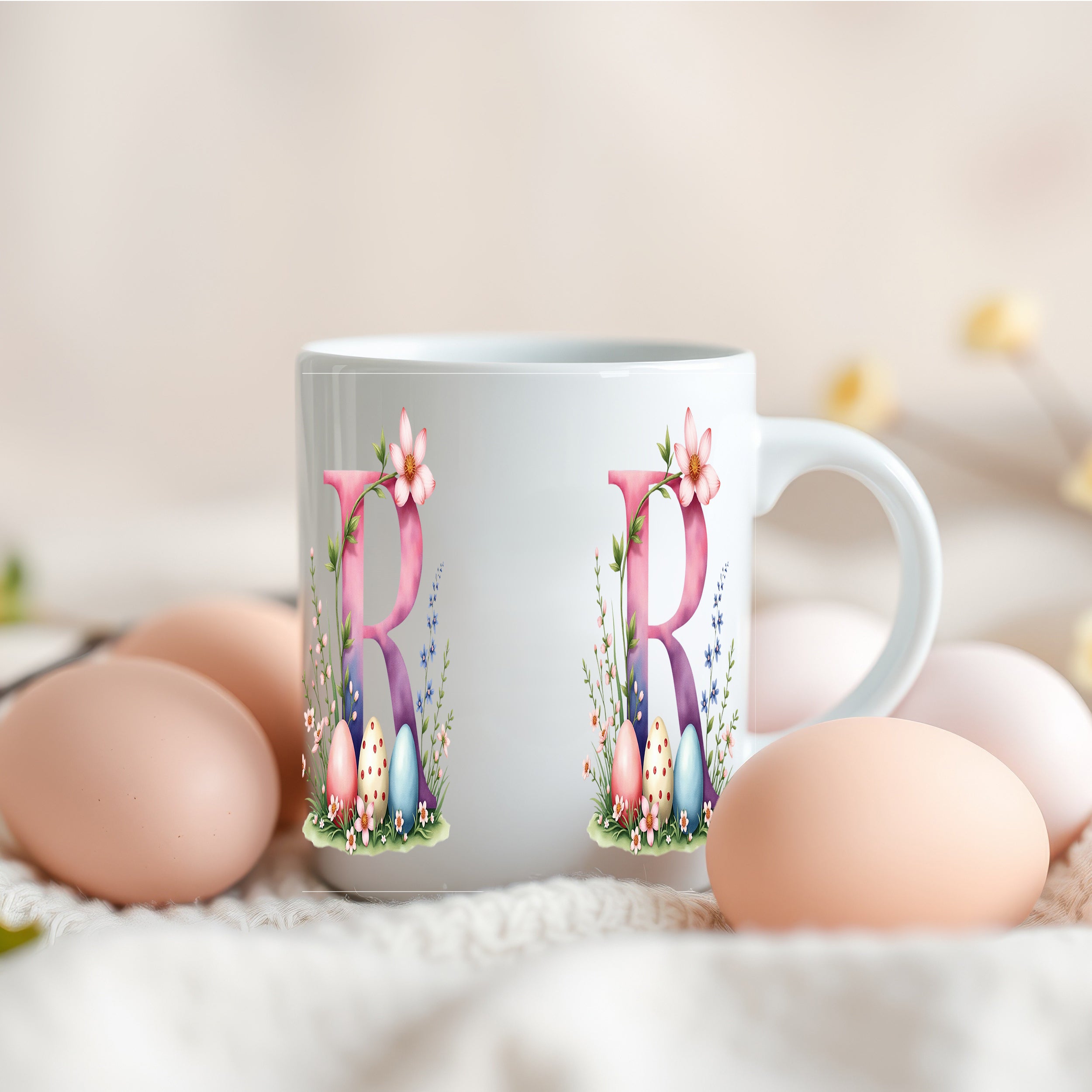 Weiße Tasse mit rosa Buchstaben und Ostereiern.