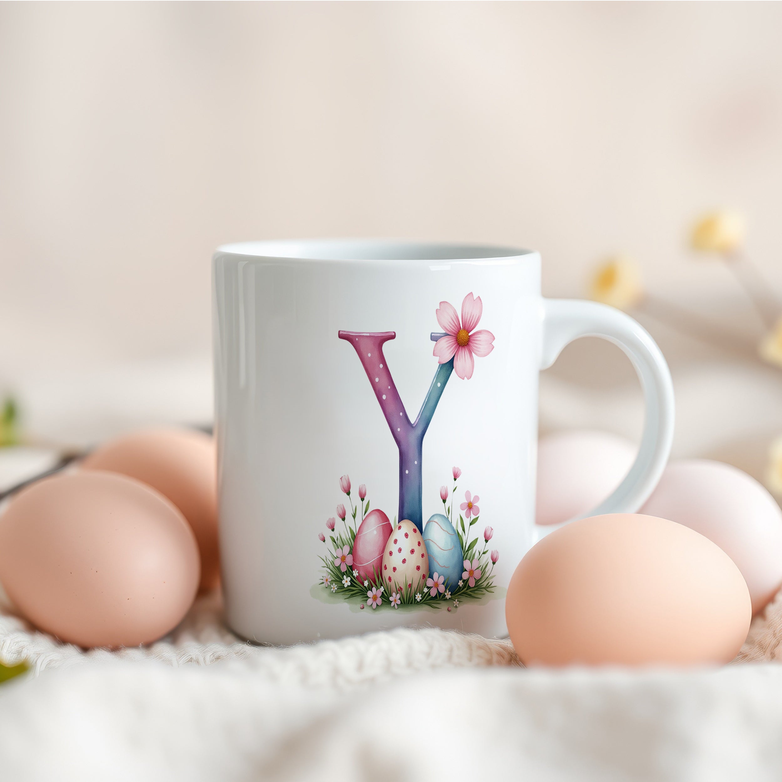Tasse mit buntem Buchstaben Y und Ostereiern.