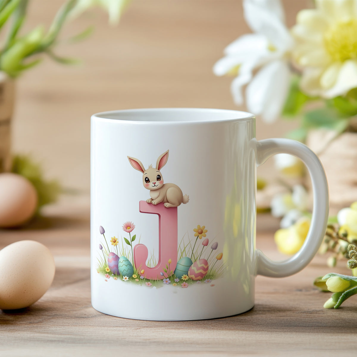 Tasse mit rosa J, Hase und bunten Eiern.