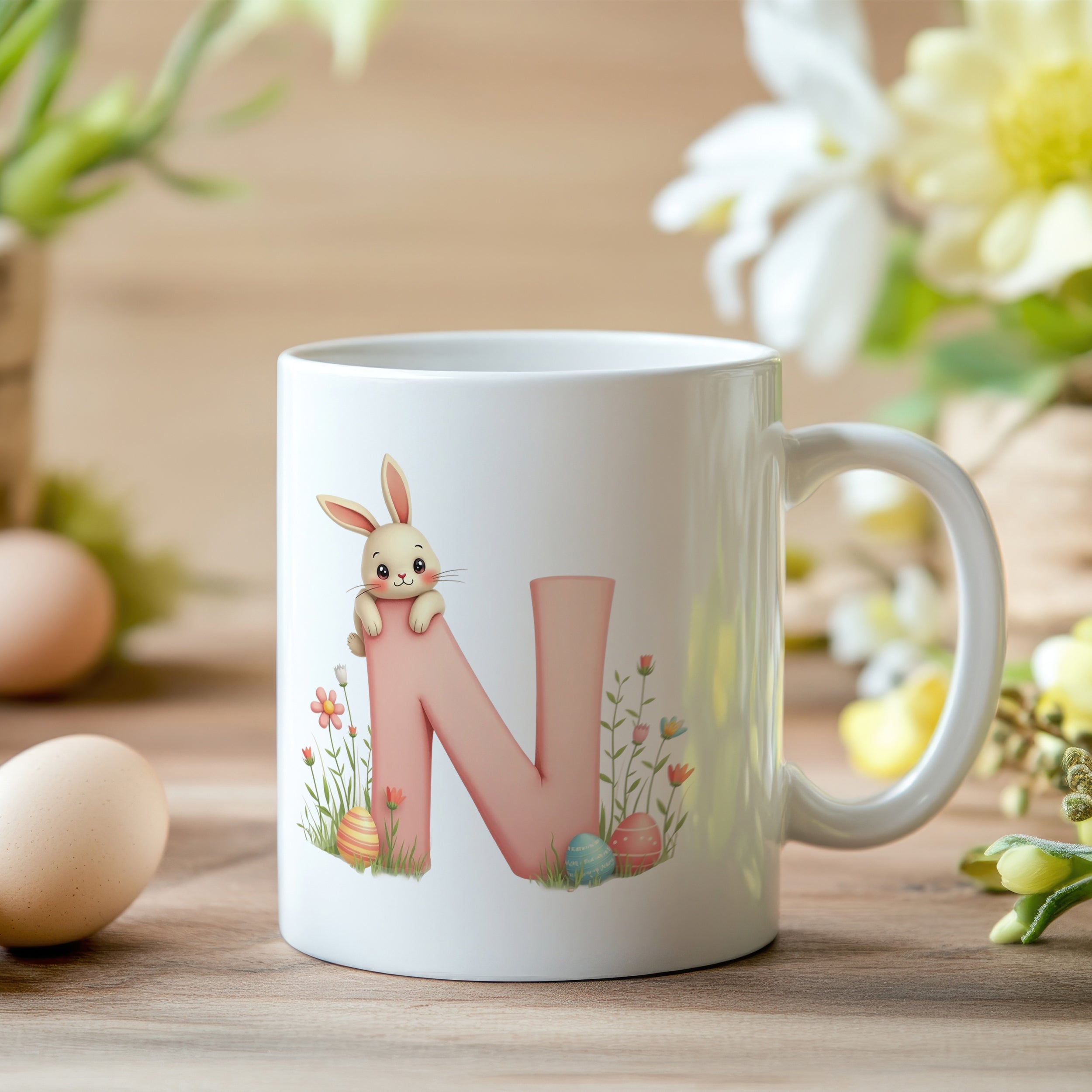 Tasse mit rosa "N", Hase und frühlingshaften Blumen.