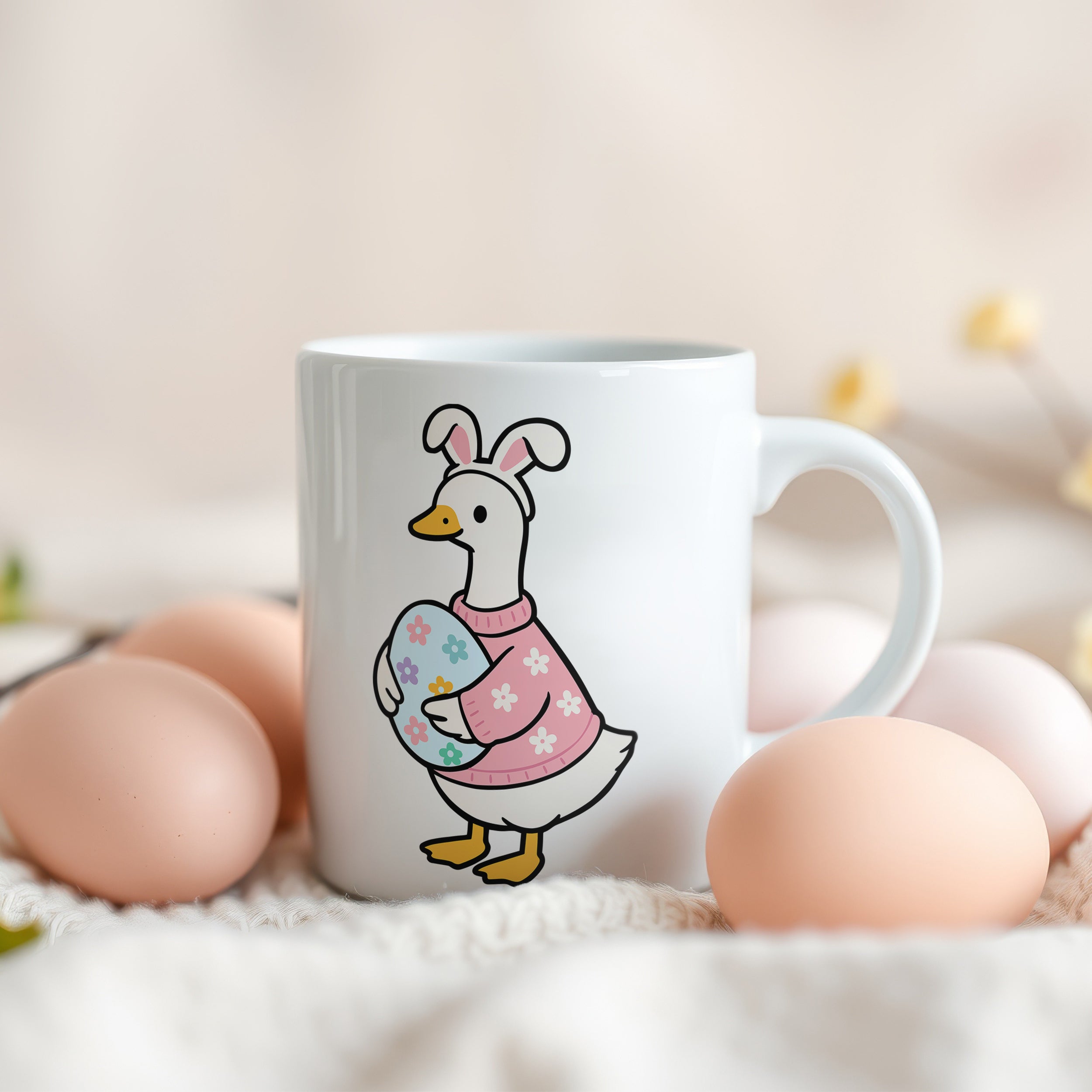 Tasse mit Entenmotiv, pastellfarbene Eier im Hintergrund.