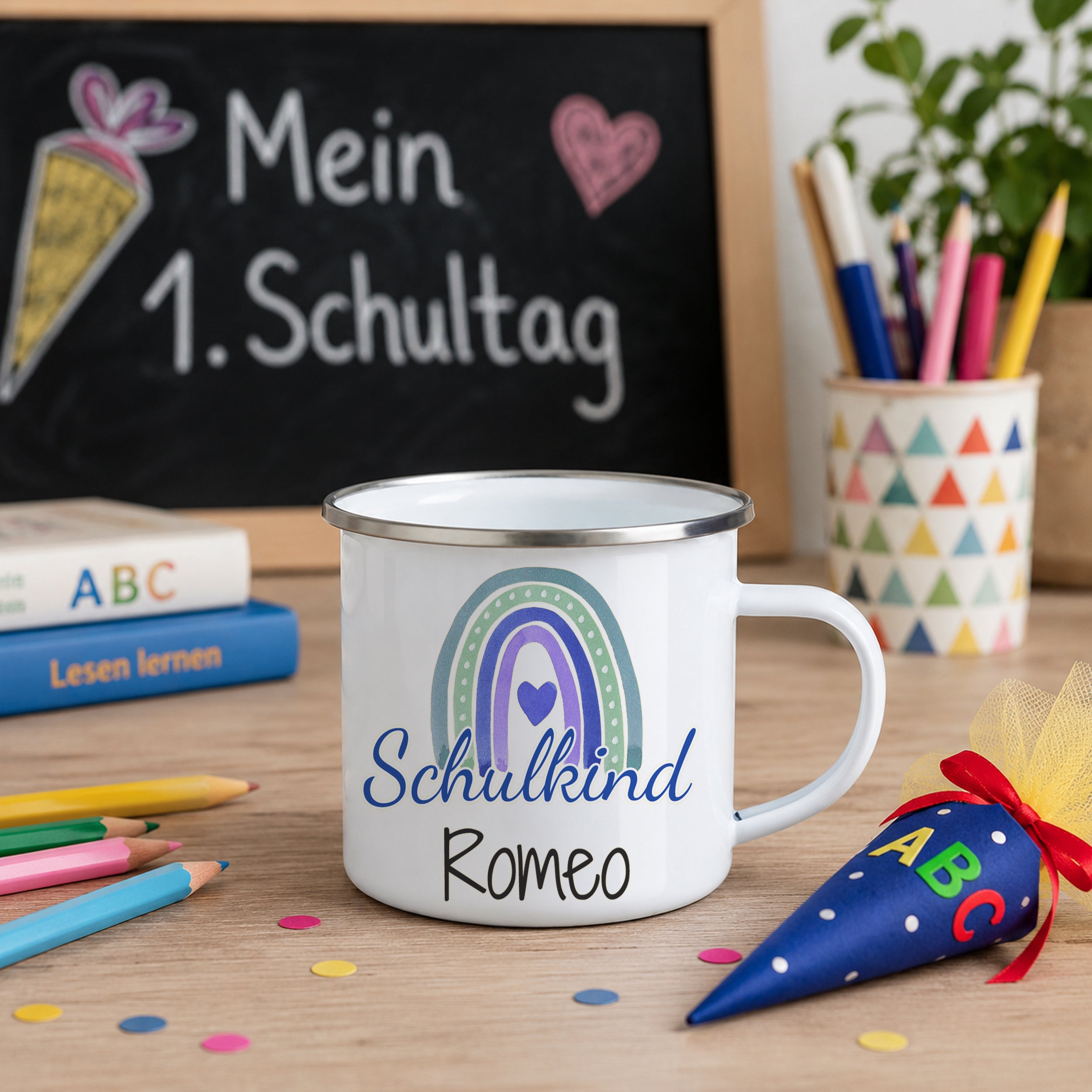 Weißer Emaillebecher mit buntem Regenbogen und "Schulkind Romeo".