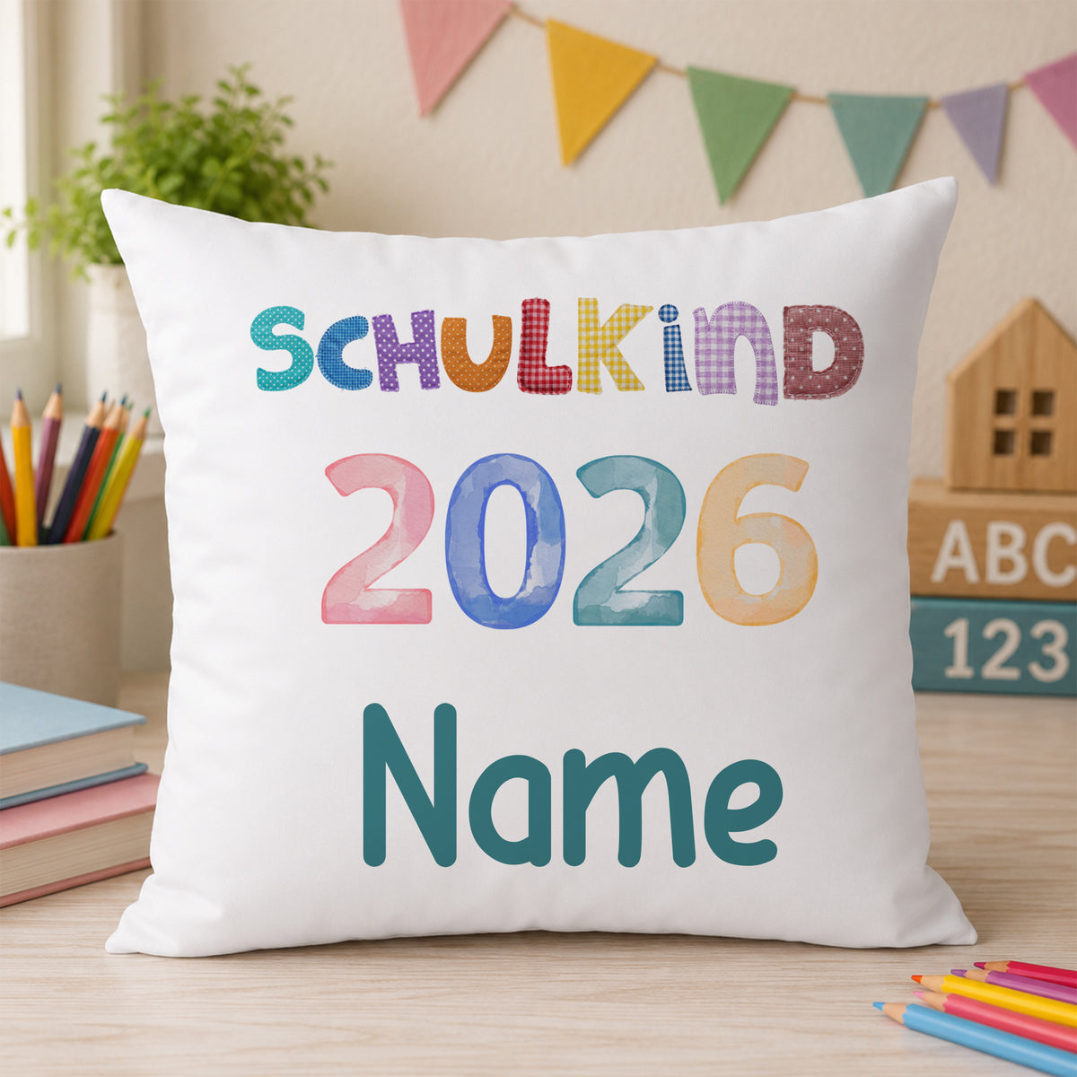 Kissen mit buntem Aufdruck "SCHULKIND 2026" und Platz für Namen.