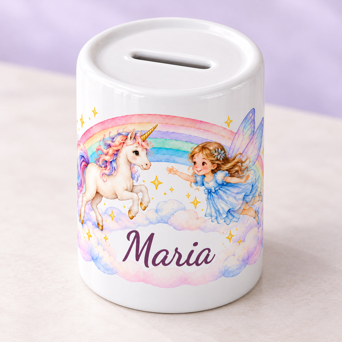 Personalisierte Keramikspardose mit einem springenden Einhorn, einer fliegenden Fee und Regenbogenwolken in schräger Ansicht mit sichtbarem Münzschlitz.