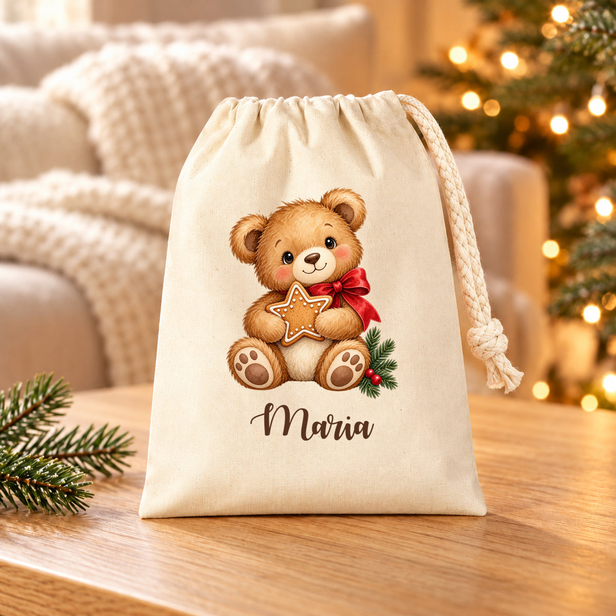 Naturfarbenes Nikolaussäckchen mit Weihnachtsbär mit Lebkuchenstern und personalisiertem Namen auf einem Holztisch vor Sofa und Weihnachtslichtern.
