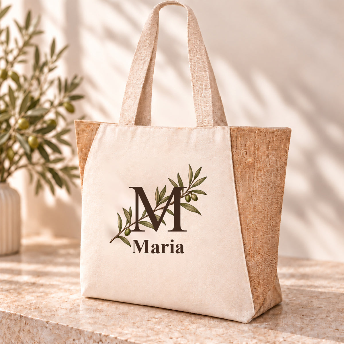 Personalisierter Shopper mit diagonalem Olivenzweig, Initial und Wunschname auf naturfarbener Front.