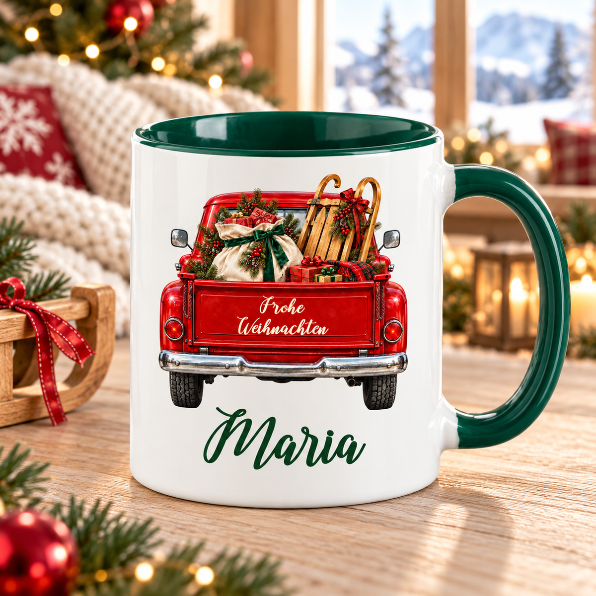 Weiß-grüne Weihnachtstasse mit rotem Truck, Motiv Schlitten und Geschenkesack, Weihnachtsgruß und einem Namen in grüner Schreibschrift auf einem Tisch in einer warmen weihnachtlichen Umgebung.