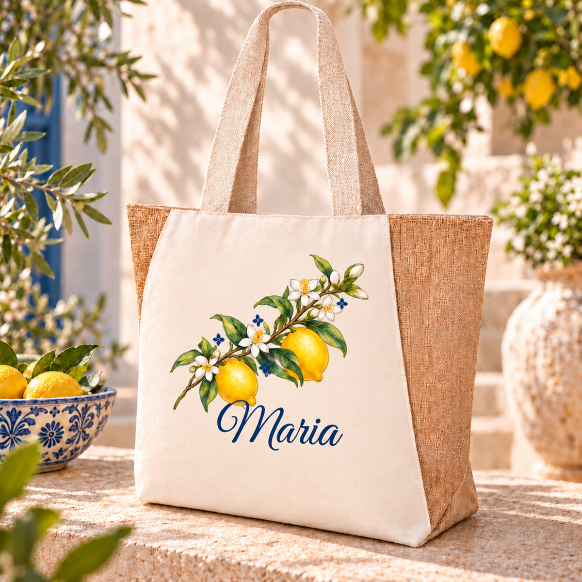 Naturfarbener Shopper mit diagonalem Zweig, zwei gelben Zitronen und blauem Wunschnamen neben einer Zitronenschale.