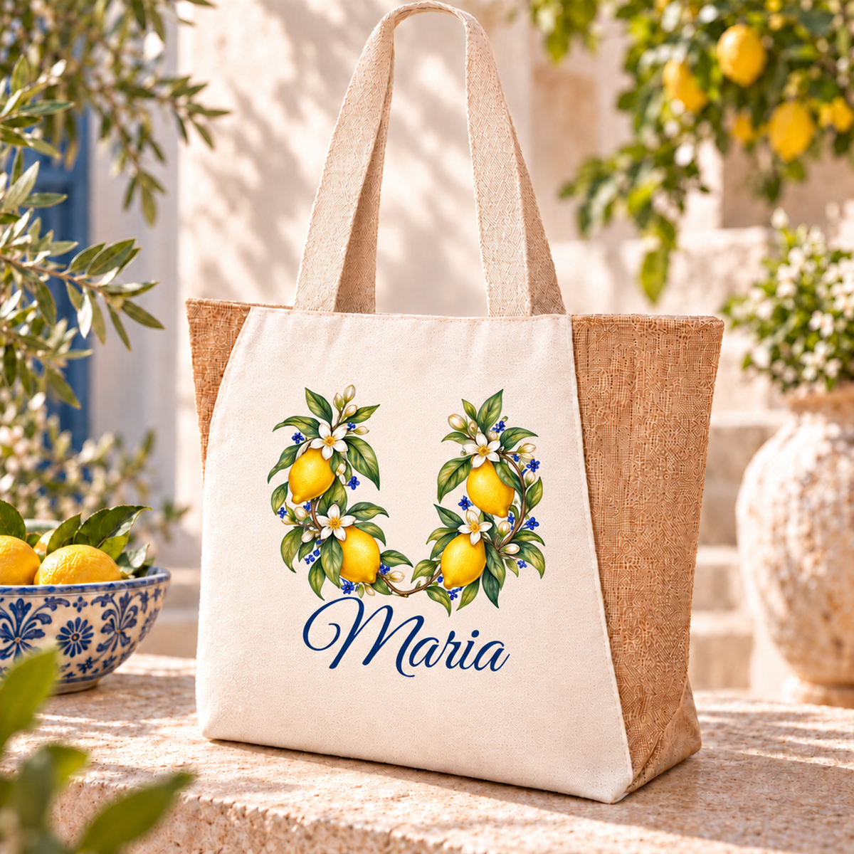 Naturfarbener Shopper mit vier Zitronen an zwei nach oben offenen Zweigen und blauem Wunschnamen auf einer Steinablage.